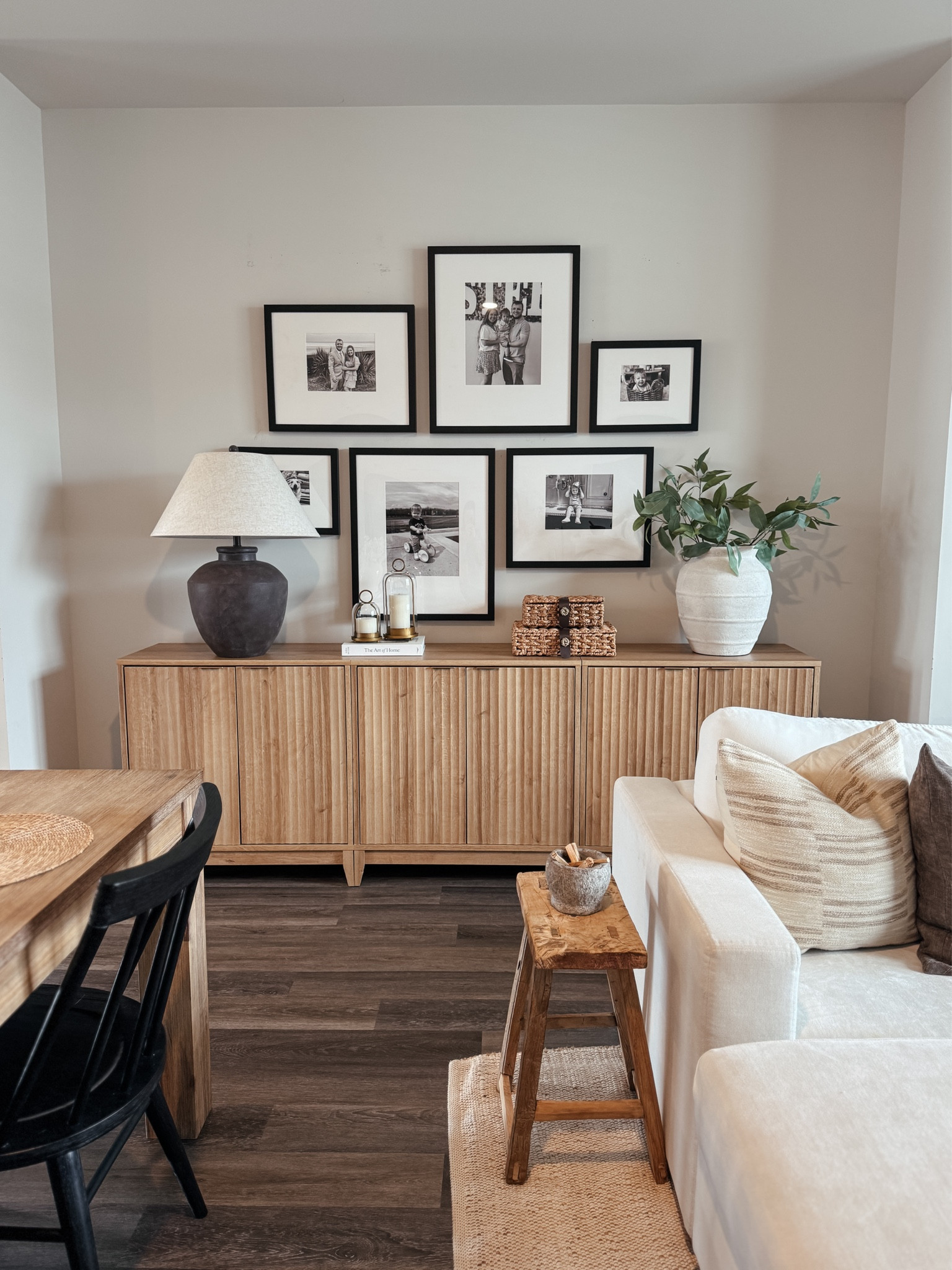Cozy neutral living room ideas that just work 🤍 This space is layered with a fluted wood sideboard, black frame gallery wall, neutral throw pillows, textured table lamp, woven baskets, ceramic vase with greenery, and a small wood stool for that warm, lived-in feel. I love mixing affordable home decor with a few timeless staples to keep things functional and beautiful for everyday life.

#ltkhome #neutralhome #cozyhome #gallerywall #affordabledecor

#LTKSaleAlert #LTKHome #LTKSeasonal