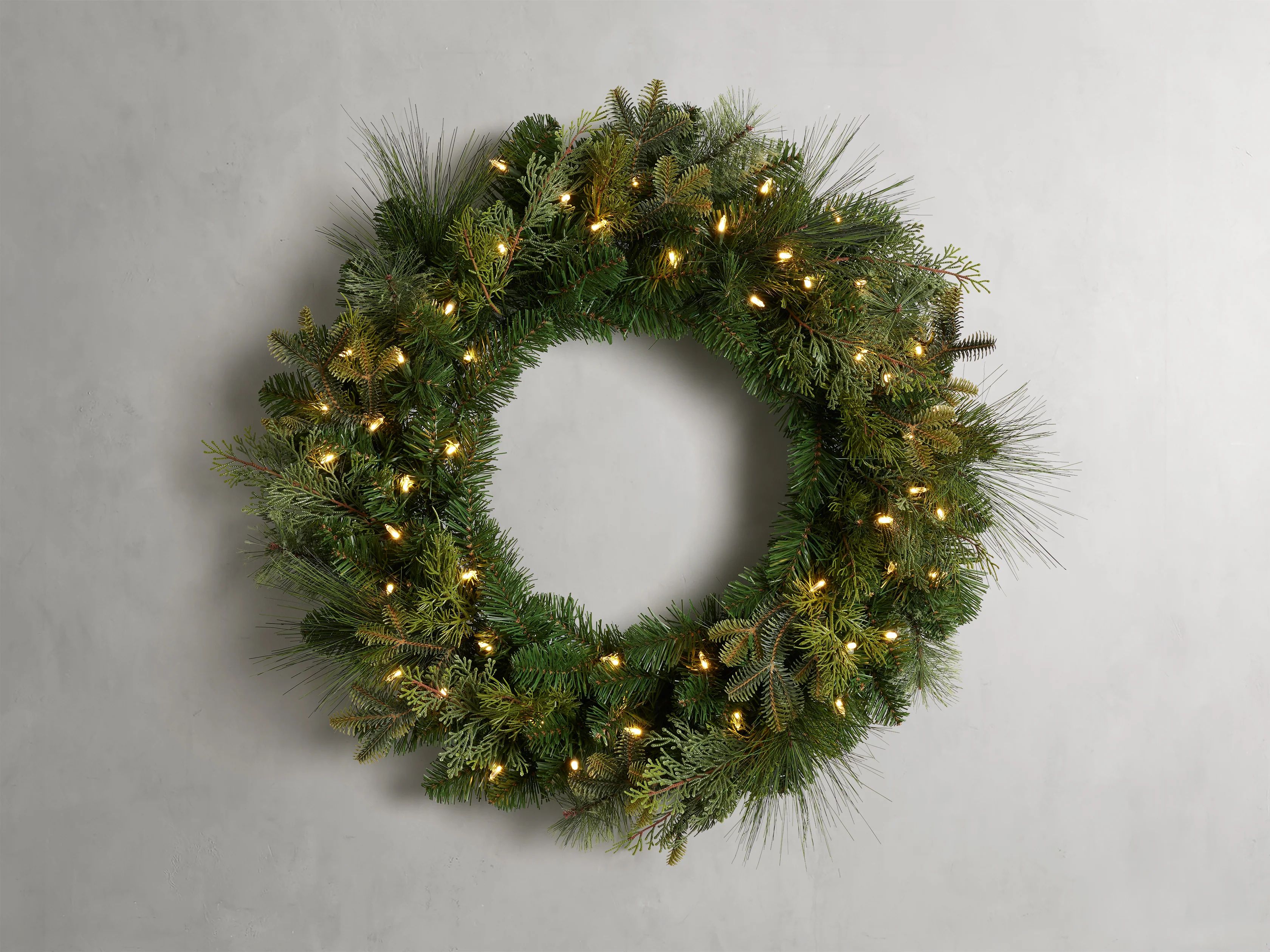 Deck the halls with our classically styled Faux Mixed Green Wreath. Strung with 50 LED warm, whit... | Arhaus