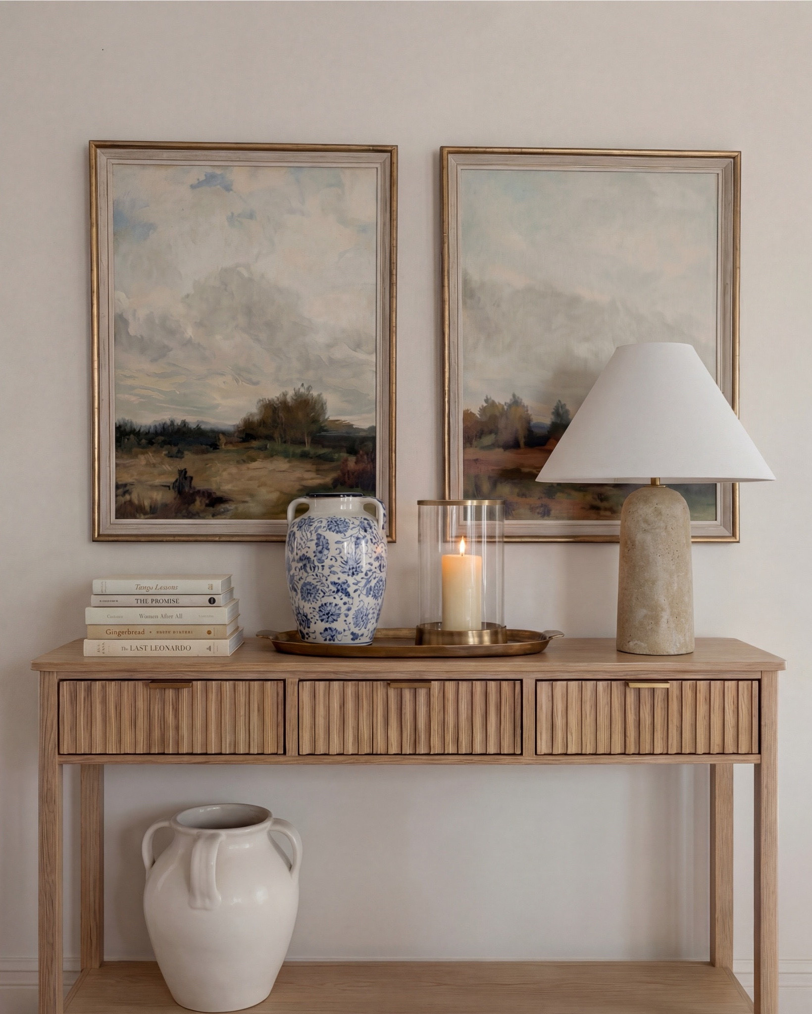 This dining room feels calm, intentional, and quietly elevated. The exposed wood beams warm up the space, while soft blues—on the ceiling and rug—bring in that serene, lived-in charm. The contrast between the dark wood table and the plush ivory chairs makes everything feel grounded yet refined.

The styling really sells it: a blue ceramic bowl centered on the table, a brass vase with organic branches for height, and layered decor along the sideboard that keeps the room from feeling too formal. It’s traditional at its core, but styled in a way that feels fresh and current.

Shop the Look:
• Dark wood rectangular dining table
• Curved ivory upholstered dining chairs (wood base)
• Blue ceramic decorative bowl (table centerpiece)
• Brass vase with dried branches
• Blue patterned area rug
• Light wood sideboard with fluted drawer detail
• Blue-and-white ceramic vase (sideboard)
• Neutral table lamp with white shade
• Stacked books + candle decor
• Framed landscape wall art (set of two)
• Dark wood arched china cabinet with glass doors
• White ceramic floor vase
• Exposed wood ceiling beams
• Soft blue ceiling paint
• Tall floor vase

#LTKsale #LTKhome #LTKstyletip