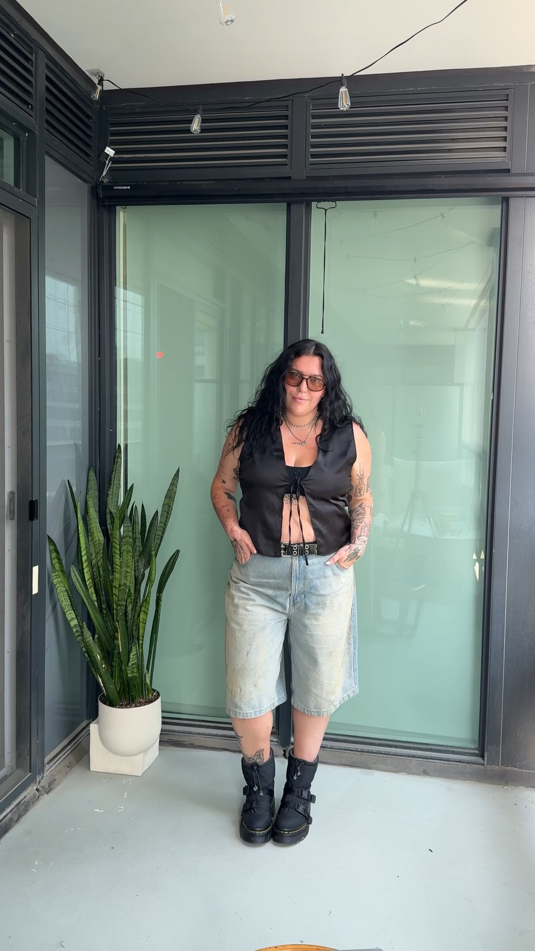 Tomboy femme but make it summer night hot 🖤 Silky tie-front top with a peek of my sternum tattoo, extra baggy denim shorts for that laid-back feel, and chunky Docs to ground the whole look. Finished it off with my fave brown lens sunnies—linked it all so you can steal the vibe 😎

#TomboyFemme #LTKStyle #SummerNightOutfit #QueerFashion #MidSizeStyle #ChunkyDocs #DenimShortsStyle #LesbianOutfitInspo #SternumTattooStyle #CoolGirlVibes 

 
