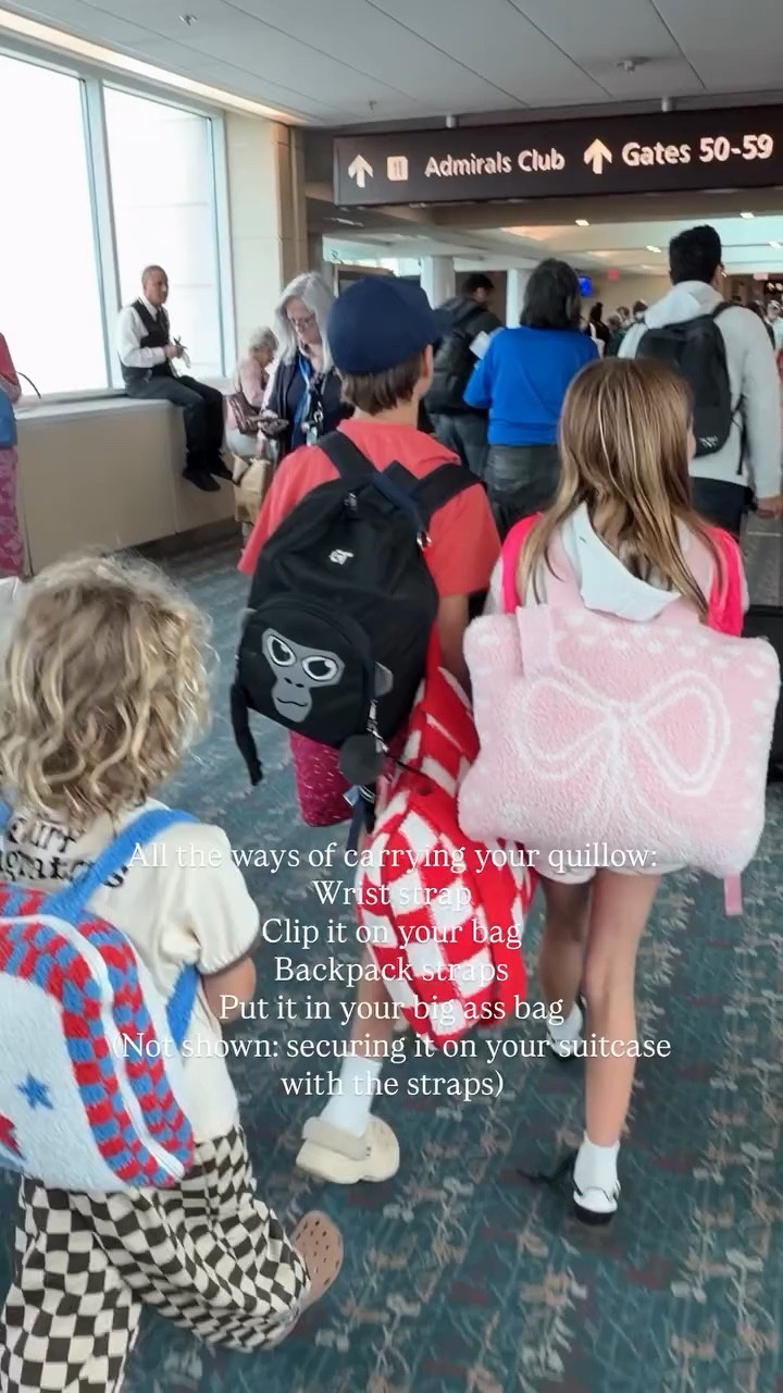 All the ways of carrying your quillow:
Wrist strap
Clip it on your bag
Backpack straps 
Put it in your big ass bag
(Not shown: securing it on your suitcase with the straps)