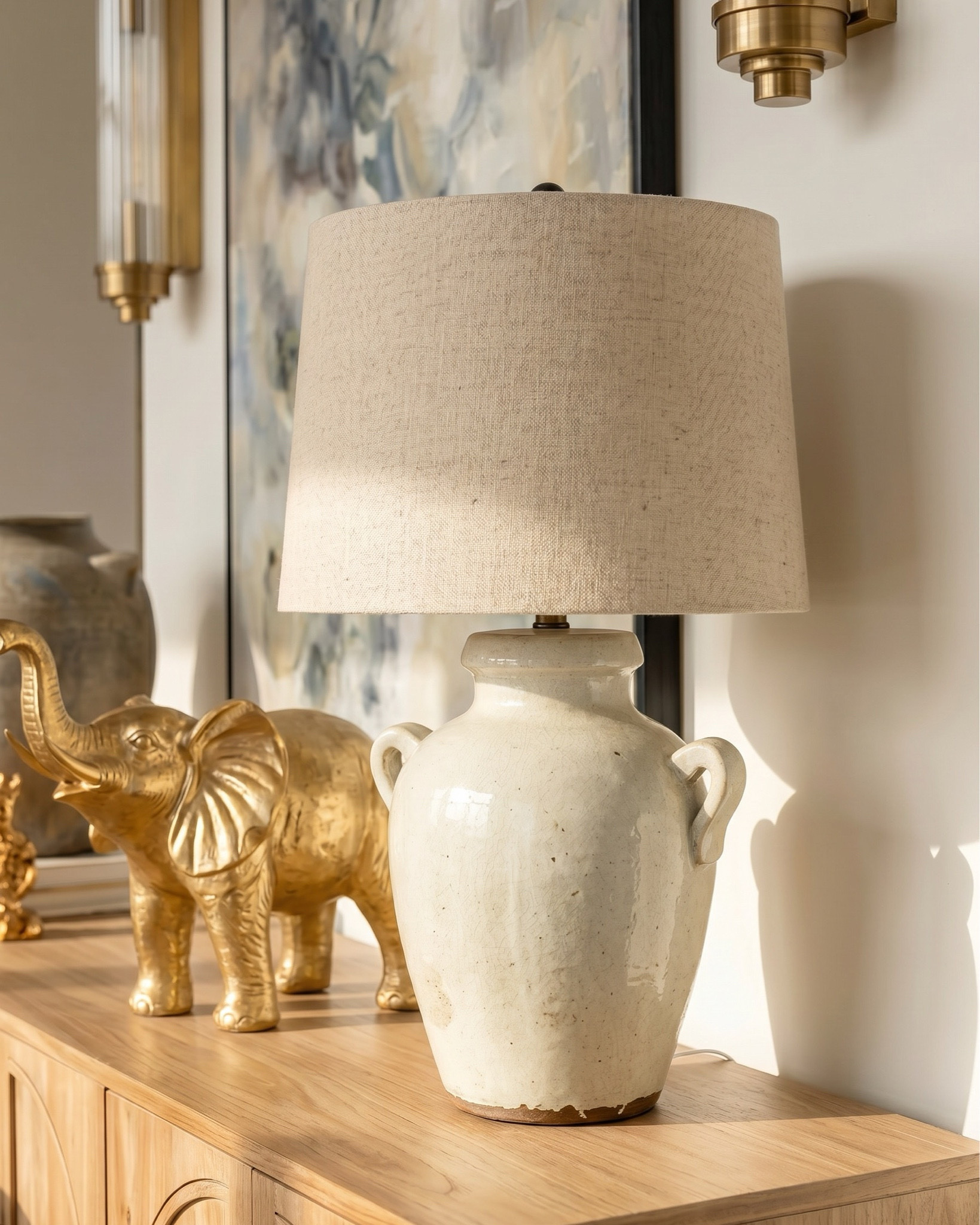 Shop the look:
* Oak wood extendable dining table
* Wood cane dining chair
* Beige jute rug
* Wood oak console credenza 
* White ceramic vase 
* Distressed terracotta vase
* Ceramic table lamp 
* Brass gold decor figures 
* Decor book 
* Oak wood display cabinet 
* Brass gold chandelier 
* Glass brass wall sconce 
* Blue subtract wall art

#LTKhome #LTKsale #LTKstyletip