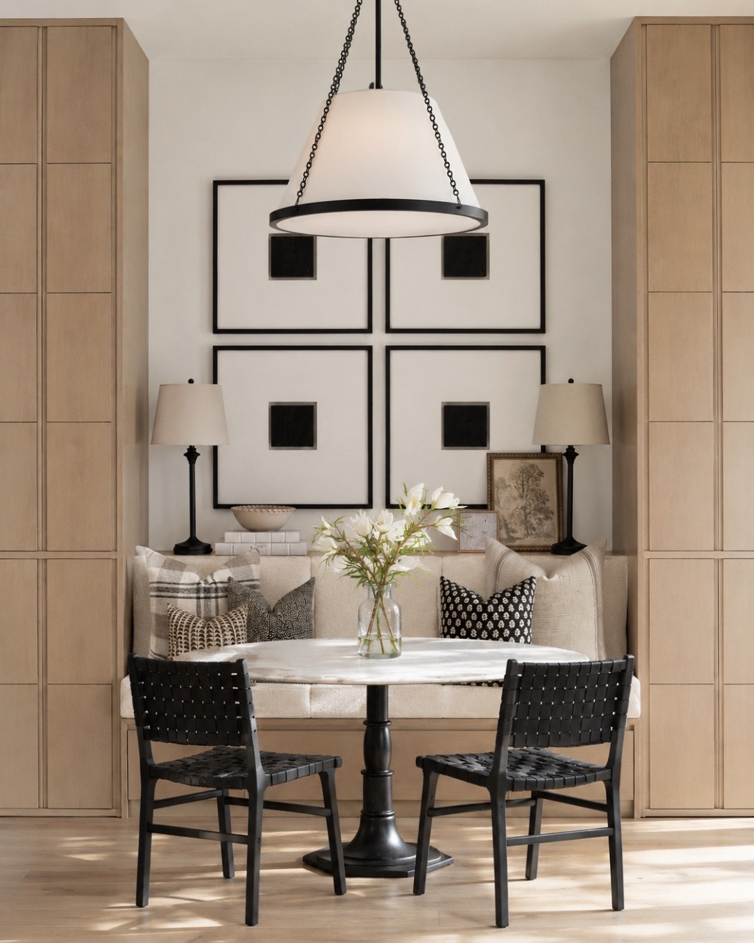 A banquette dining nook is one of the best ways to make a kitchen feel custom. I love the mix of a marble pedestal table, black woven dining chairs, built-in bench seating, tall wood cabinets, table lamps, framed art, and layered pillows. It feels cozy, functional, and designer without overcomplicating the space.
I may receive a commission when you shop through my links.

#LTKHome