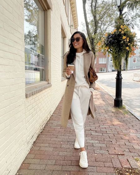 Kat Jamieson of With Love From Kat wears a fall outfit. White sweatpants, white sweatshirt, tan coat, brown clutch, tan sunglasses.

#LTKstyletip #LTKSeasonal