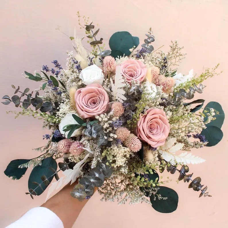 Soft, airy, and effortlessly elegant—this Blush Ivory Roses & Lavender bouquet by Bridalwishdesign is a timeless choice for brides who love neutral tones. Designed with preserved roses, eucalyptus greenery, peach-pink globe amaranth, baby’s breath, delicate dried grasses, and fluffy bunny tails, it creates a romantic blend of blush, ivory, and sage. Available in multiple sizes for everything from intimate ceremonies to statement bridal moments, this everlasting arrangement transitions beautifully from wedding day to home décor. A keepsake bouquet you’ll cherish for years to come. 🤍🌿 #LTKwedding #NeutralBouquet #DriedFlowers #BridalInspo #BohoBride #EucalyptusLove #EverlastingFlorals

#LTKHome #LTKSeasonal #LTKWedding