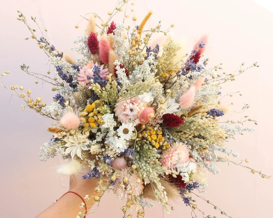 Soft, romantic, and effortlessly timeless 🌾 This peach and lavender dried wildflower bouquet is a stunning choice for brides who love natural beauty with a whimsical touch. Handcrafted with fragrant strawflowers, fluffy bunny tails, silvery herbs, and soft pink globe amaranth, each bouquet is truly one of a kind and designed to last long after the wedding day. A perfect keepsake that captures the charm of wildflowers in full bloom.
#LTKWedding #BridalBouquet #DriedFlowerBouquet #BohoBride #WeddingInspo #EtsyFinds #PreservedFlowers #BridalStyle

#LTKFindsUnder100 #LTKHome #LTKSeasonal