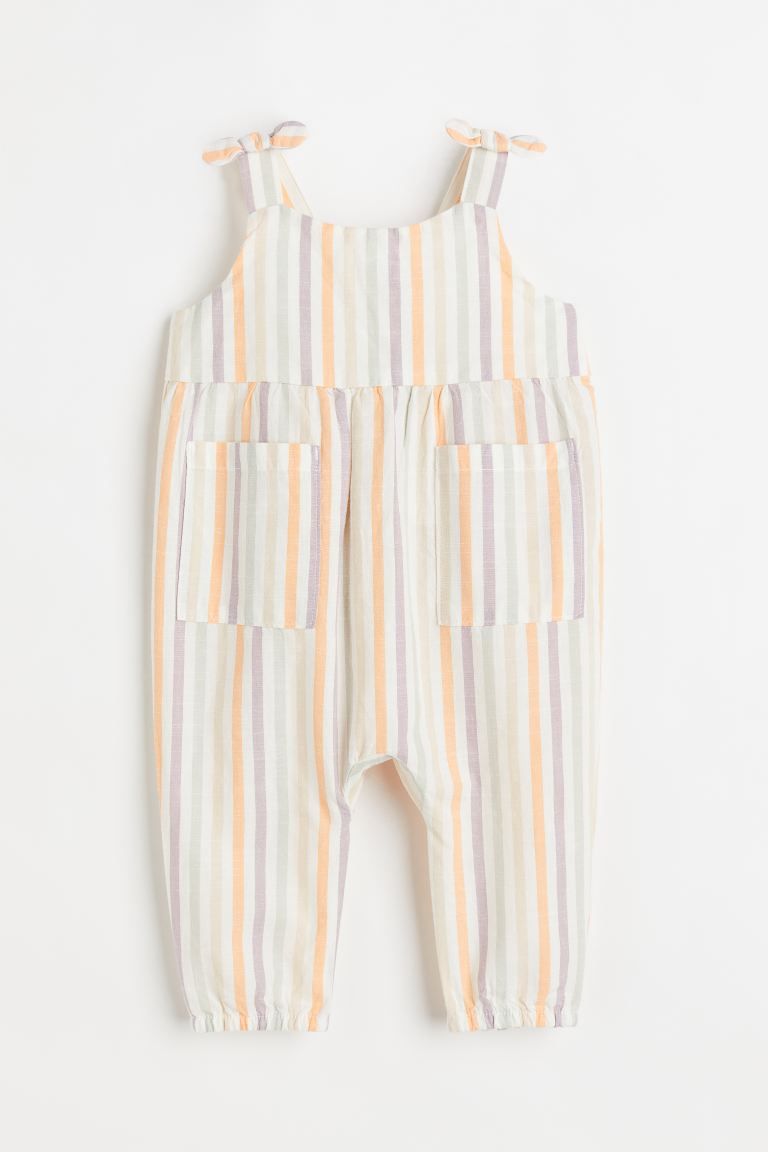 Sleeveless romper suit in woven cotton fabric. Shoulder straps with decorative ties at top. Butto... | H&M (US + CA)
