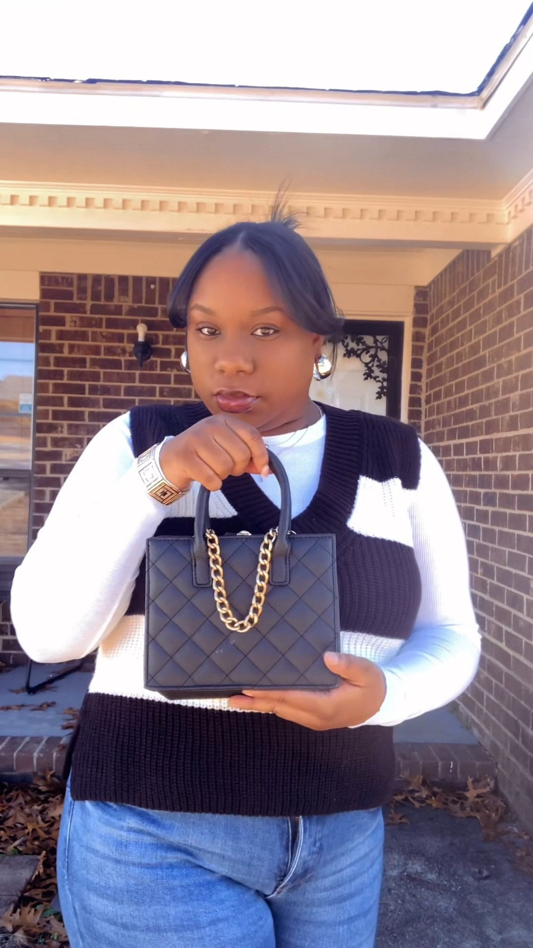 Black bag gold chain, gold hoop earrings, white long sleeve top, striped vest 

#LTKfindsunder100 #LTKVideo #LTKmidsize