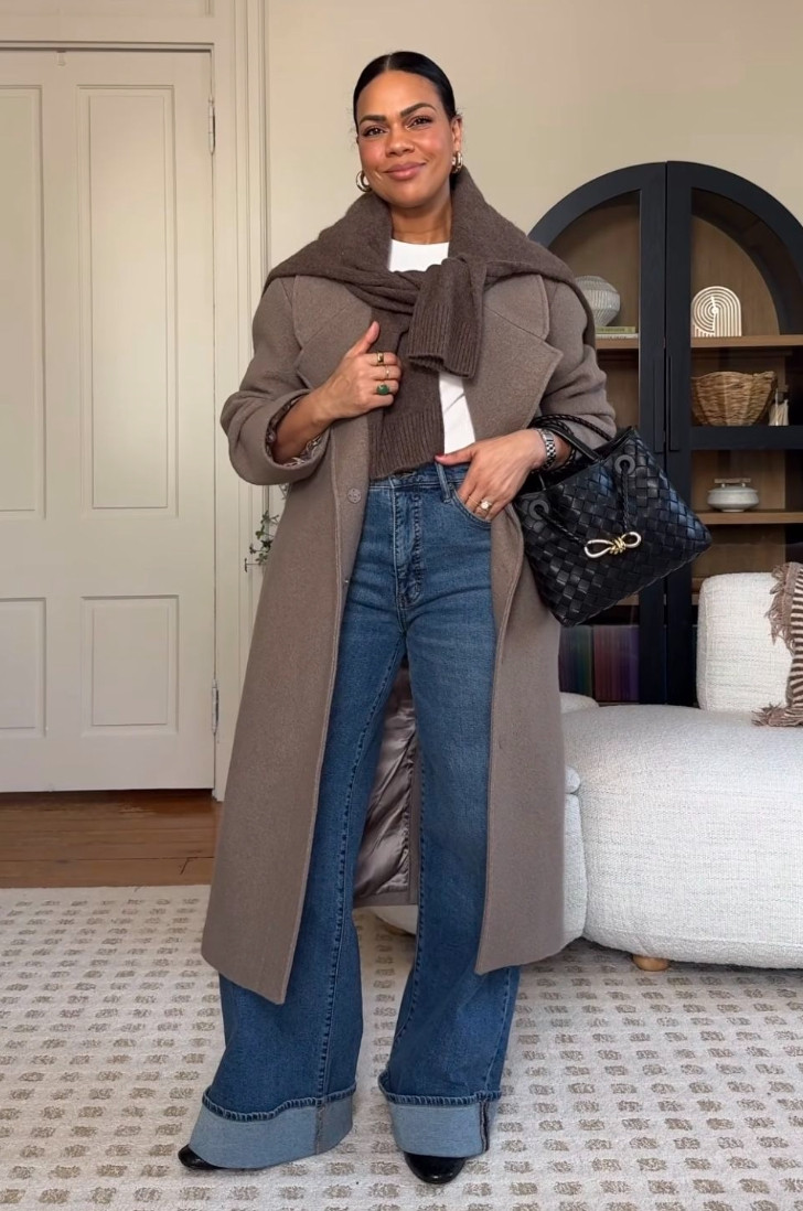 This cozy elevated outfit pairs wide-leg jeans with a tailored wool coat and sweater draped over the shoulders for a timeless fall-winter look.
Rich neutral layers, classic denim, and a structured handbag create a polished everyday style that feels warm, effortless, and quietly luxurious. 

 #LTKdayinmylife #LTKootd