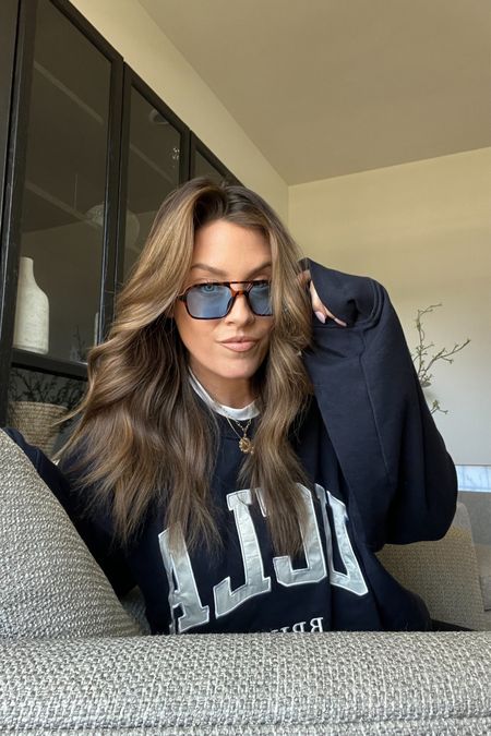 UCLA sweatshirt and blue lens Amazon sunglasses 