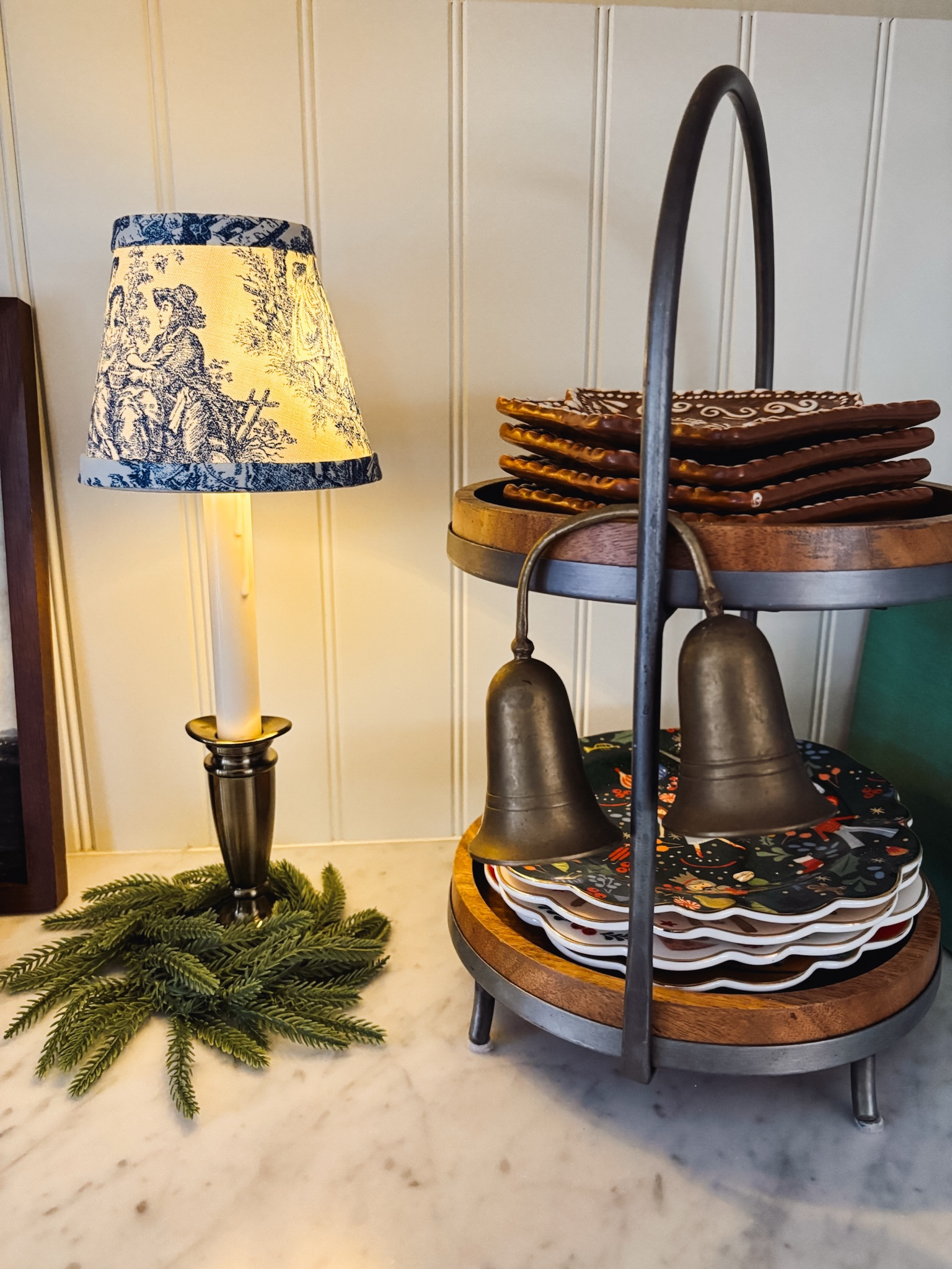 Window candle with blue toile lampshade, mini wreath, wood tiered stand, gingerbread house plates and nutcracker 12 days of Christmas places