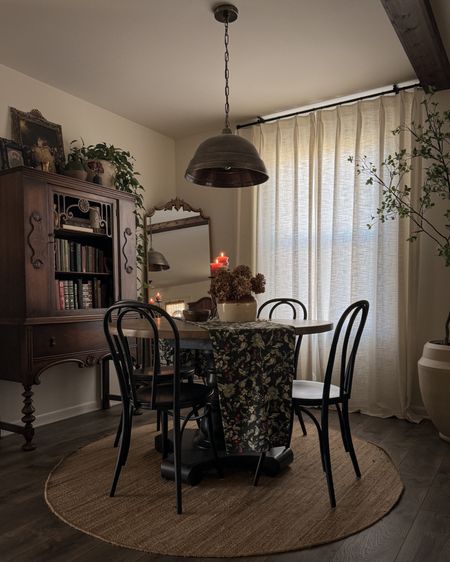 Dining room, bronze metal pendant, triple pinch pleat curtains, black chairs, round jute rug 

#LTKHome