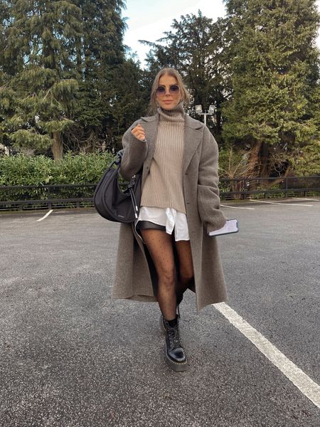 Winter outfit 
Oversized wool coat 
Knitted roll neck sweater / jumper 
Oversized white shirt
Leather look shorts
Sheer tights
Dr marten boots
Raybans
Ganni baguette bag 

#LTKeurope #LTKstyletip #LTKshoecrush