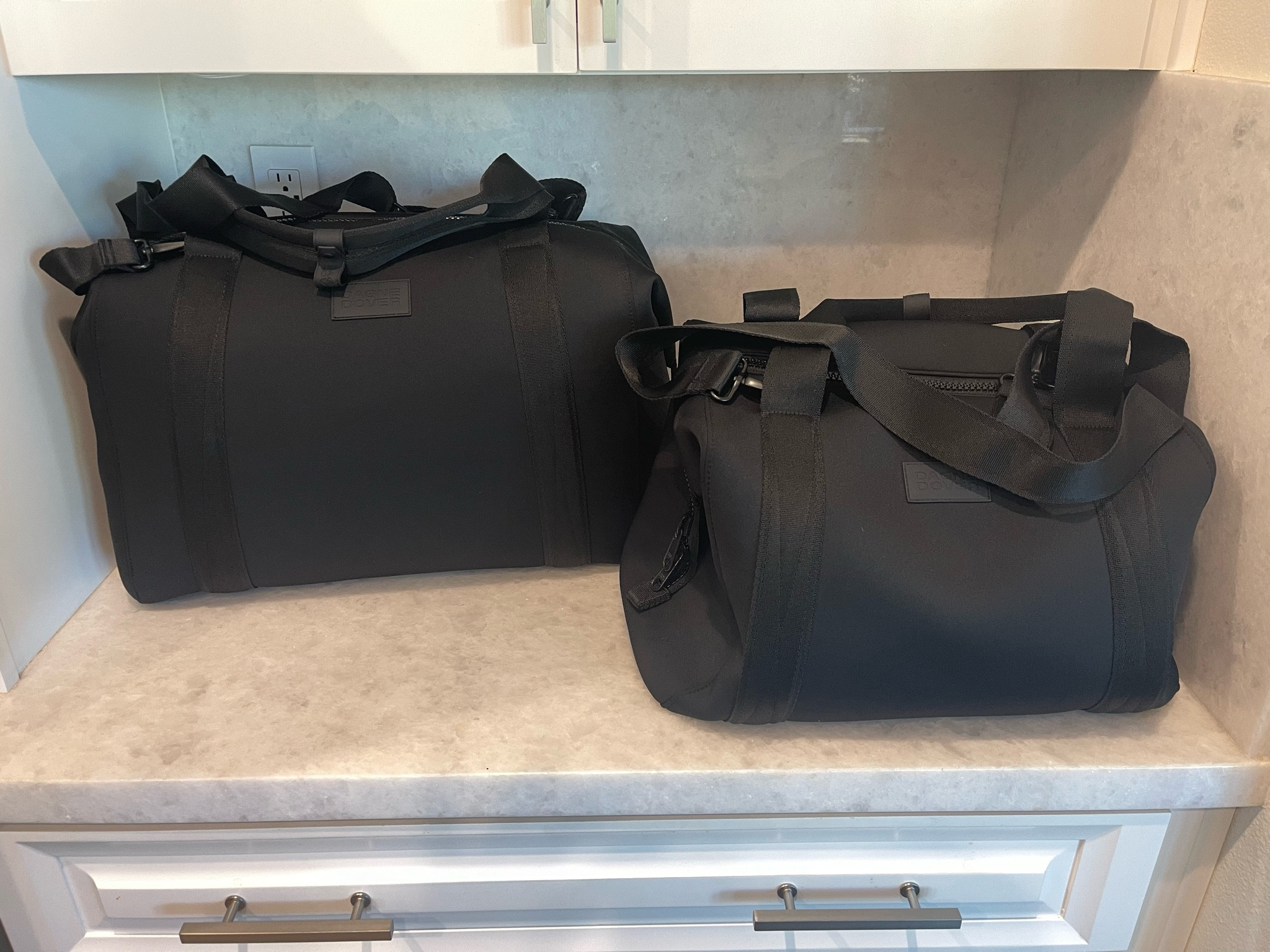 I’m totally obsessed with both of these bags from Dagne Dover  The material is neoprene and I absolutely love it. Some of the reviews say that the bag gets a little heavy but I haven’t had that issue yet. I also love all of the black hardware. These have been really fun and practical and you can easily compare the two sizes when they’re next to each other like this. I prefer the larger one, but it’s too big to carry on an airplane as your personal item. #travel #travelbag #weekender

#LTKtravel #LTKHoliday #LTKitbag