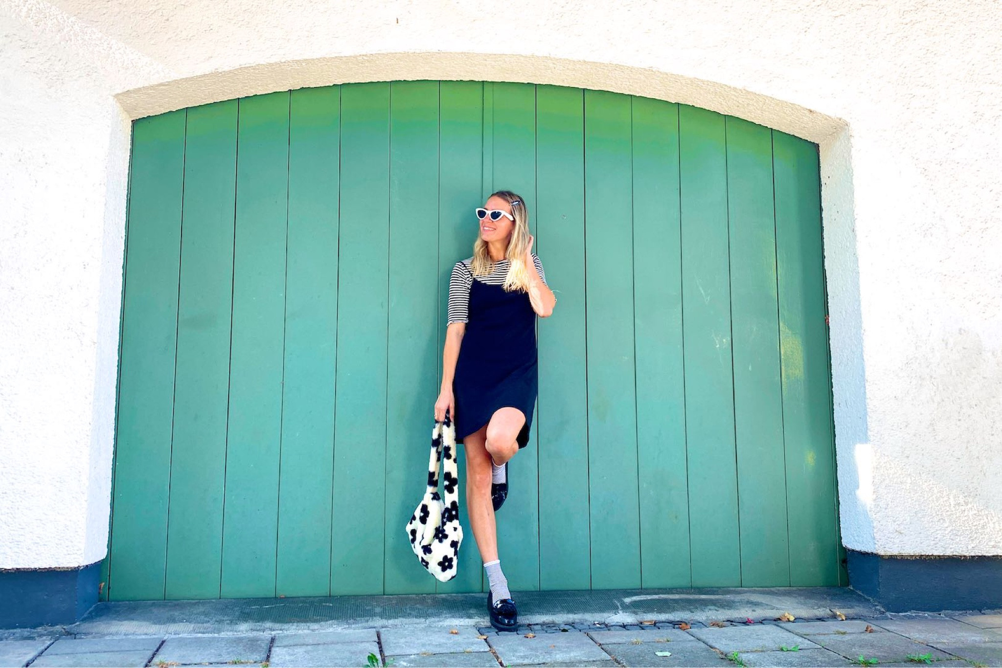 Summer Into Fall. Fashion Blogger Girl by Style Blog Heartfelt Hunt. Girl with blond hair showing her summer into fall look wearing a striped T-shirt, black slip dress, white cat-eye sunglasses, floral faux fur bag, striped socks and loafers. #colorfuloutfit #colorfulstyle #colorfulfashion#colorfullooks  #fashionfun #cutesummeroutfit #summerfashion2022 #summerlookbook #fitcheck #dailylooks #dailylookbook