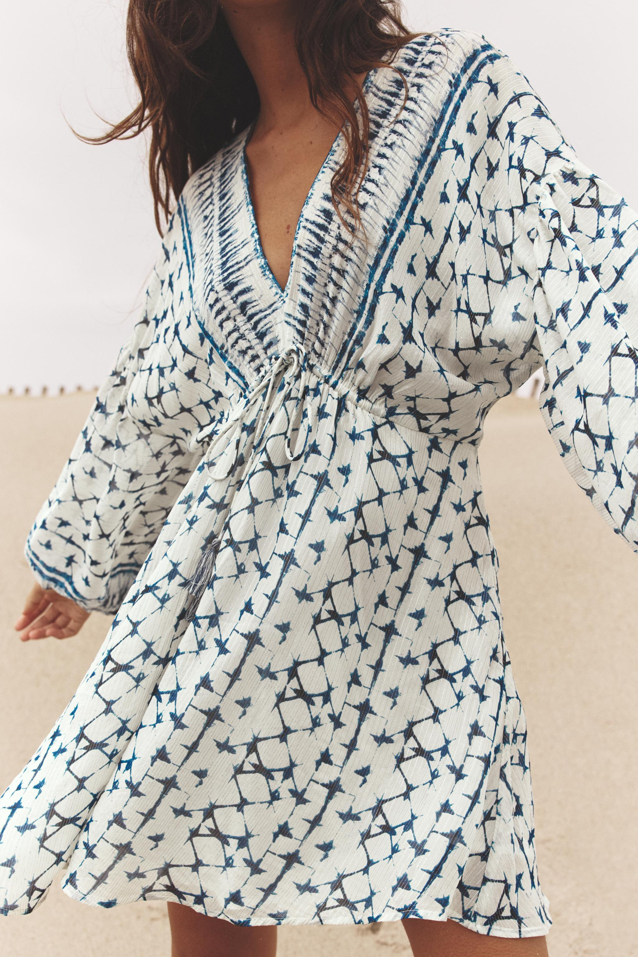 V-neck dress with long sleeves and elastic cuffs. Adjustable drawstring waist with tassels. Print... | Zara US
