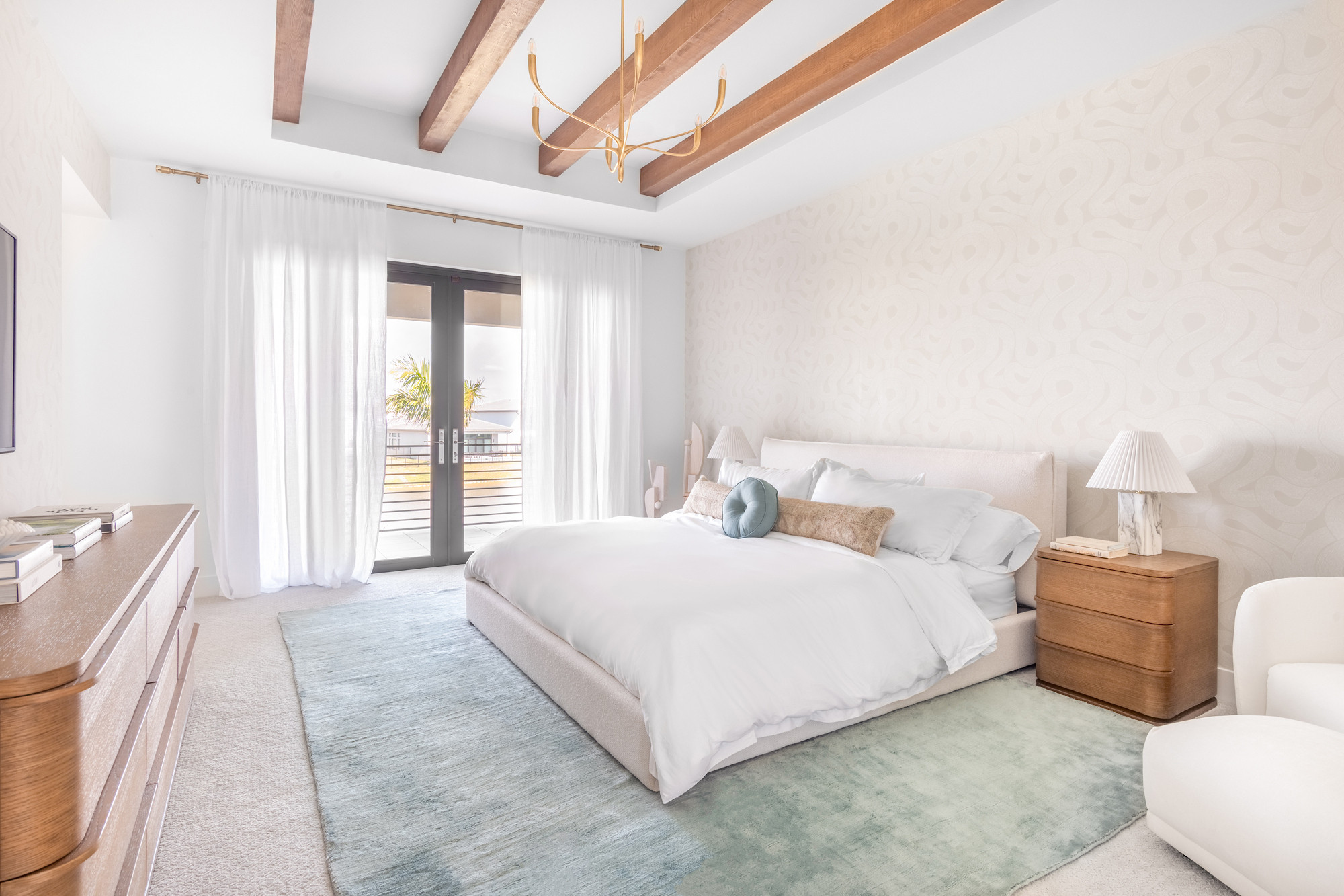 Step into serene sophistication with this dreamy primary bedroom retreat. The space is anchored by elegant faux wooden ceiling beams that add warmth and architectural interest, drawing the eye upward and creating a cozy, yet airy ambiance. A soft, velvety area rug underfoot adds plush texture and sets the stage for the bed, which is layered in crisp white linens and calming neutral tones.  

 #LTKHome