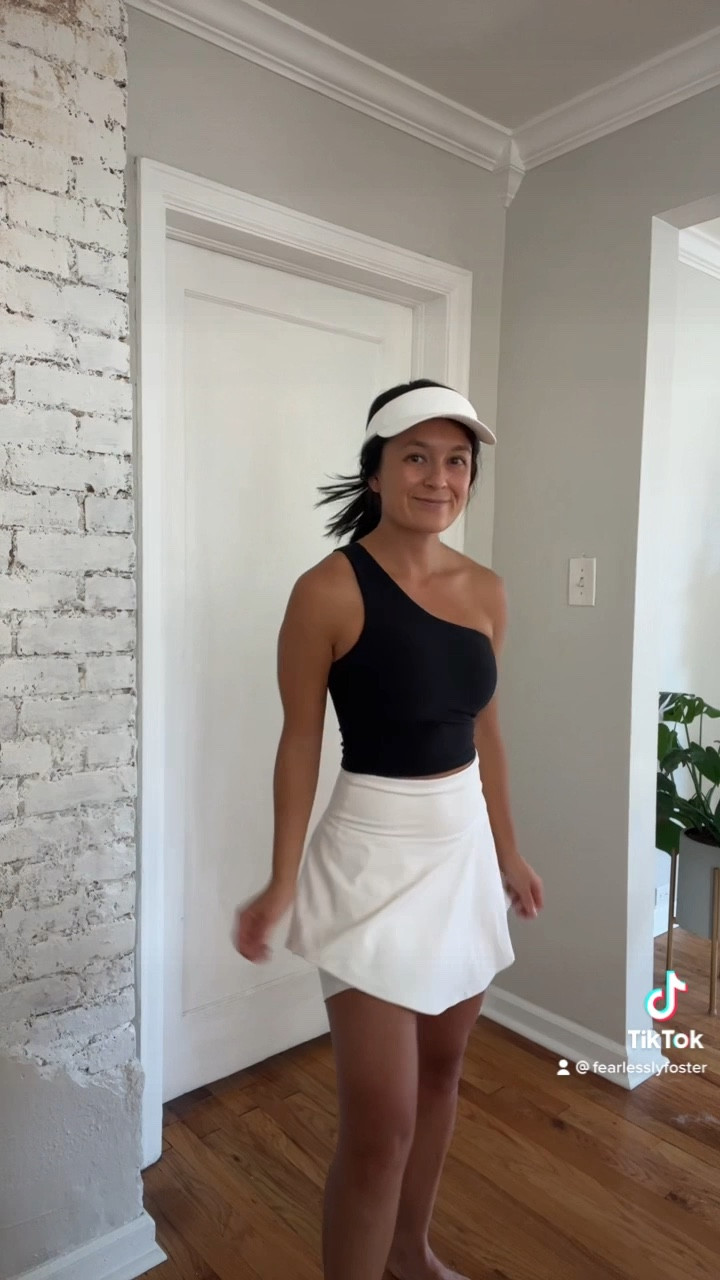 Golfing outfit. Tennis outfit. Workout outfit. Athletic outfit. Tennis skirt. Skirt. Pleated skirt. White skirt. Black tank. One shoulder tank. Sun visor. White visor. Athletic hat. White sneakers. 

#LTKstyletip #LTKunder100 #LTKtravel