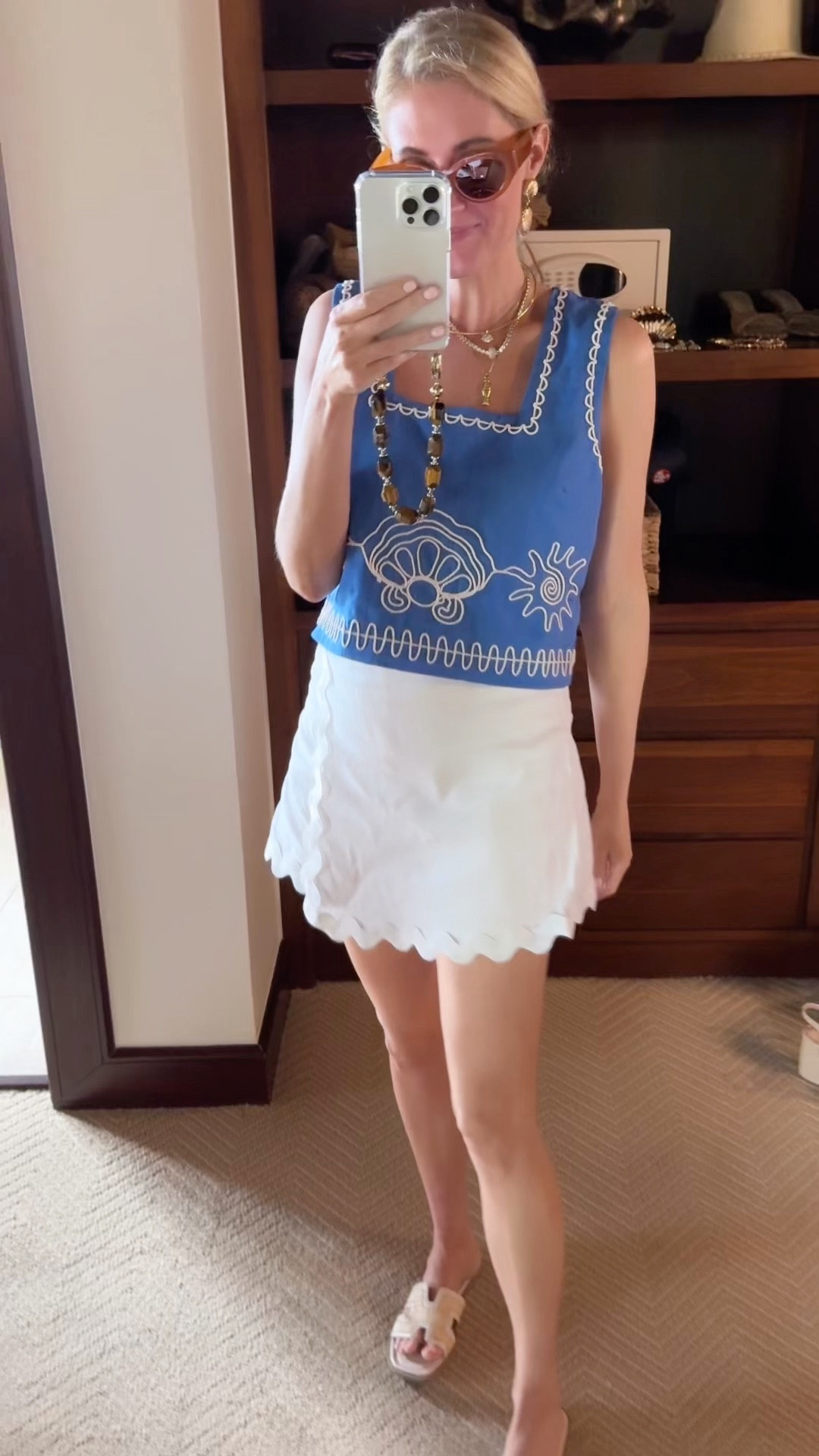 Resort outfit featuring a blue sleeveless top and white scalloped skirt, styled with neutral accessories for tropical travel.

#LTKootd #LTKdayinmylife