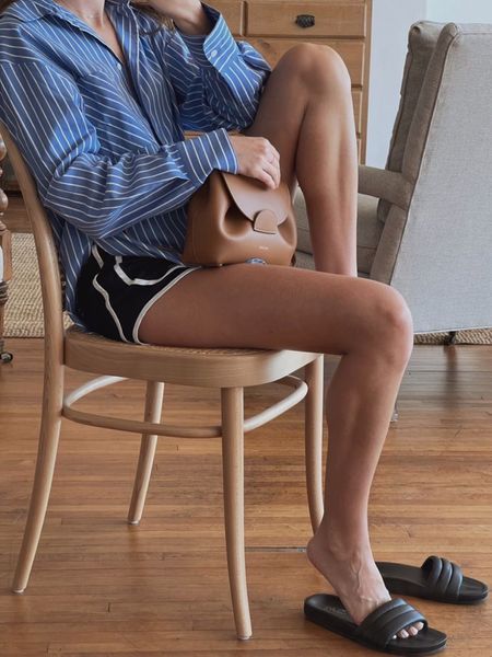Caroline Joy of Unfancy wears a casual summer outfit featuring a Reformation blue stripe button down shirt, Nike running shorts, Seychelles slide sandals, and Polene bag. Perfect for a coffee run. 

#LTKSeasonal