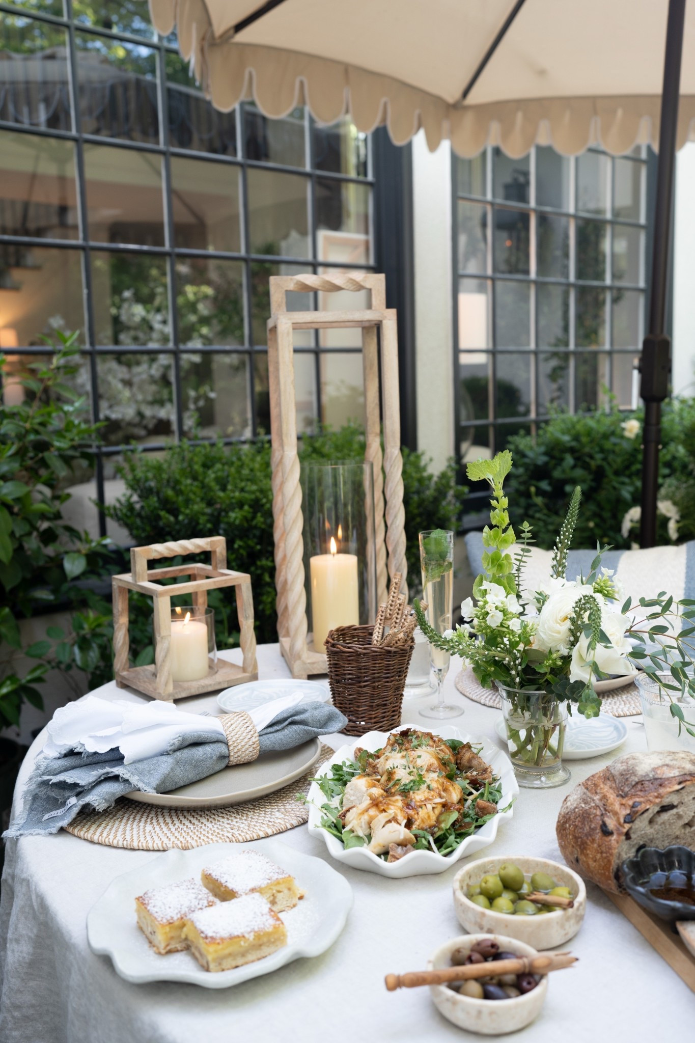 Truly living in a dream! Gorgeous wood lanterns, flickering candles, layered linen napkins, and the prettiest little plates—all set against a backdrop of green hedges and golden light. It's simple, it's slow, it's gathered. Pure magic for an evening outdoors!

#LTKHome #LTKSeasonal #LTKMothersDay