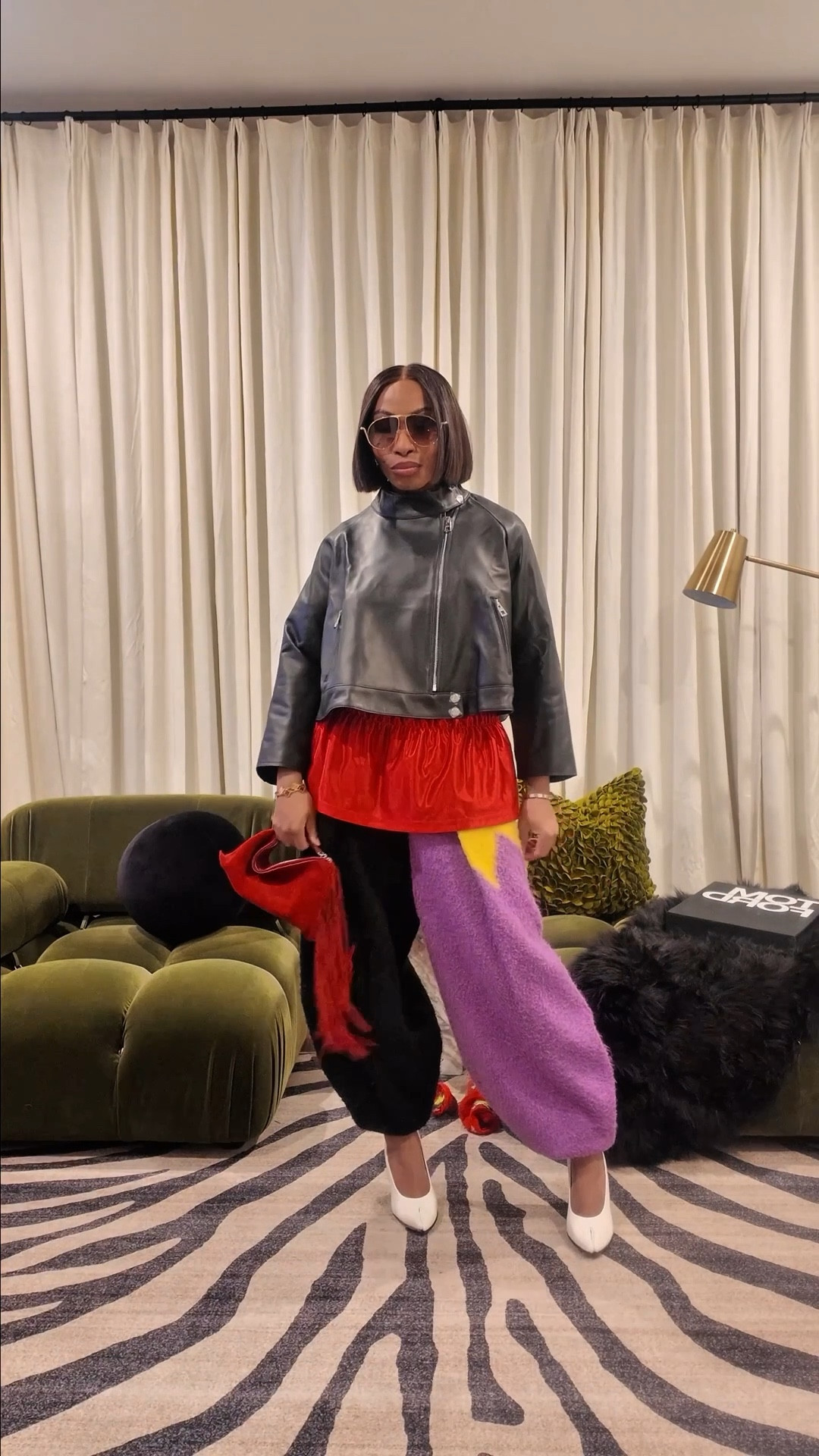 New In Item! Let’s build a look around it. 
This A-line trapeze Loewe jacket needed a base that could hold its own, and this was the starting point.

With a super-cropped, sculptural jacket, proportions do the heavy lifting. A high-waisted, voluminous bottom keeps the silhouette intentional and lets the jacket float instead of cutting the body off. The oversized jersey up top adds contrast and texture, grounding the structure of the jacket once layered.

Color is key here. The mix of red, purple, black, and a hint of chartreuse brings life and dimension to a black outer layer so it doesn’t feel flat or overly sharp. 

When the base outfit already has movement and personality, the jacket becomes an accent—not a takeover.

Finished with a white pump to soften the strength of the look. It breaks up the darkness, adds polish, and keeps the outfit from feeling too heavy at the bottom.

Strong shapes. Playful color. Clean contrast.
That’s how you let a statement jacket enhance the outfit, not overpower it bc sometimes the coat is the ACCENT and not the OUTFIT.  Which do you subscribe to? (Vote in Poll)

But the jacket is 🔥, right?! Let me know how you’re loving the look. Sound off below in the comments. 

For 🔗s to the outfit, check out my LTK page. If you want the links sent to your directly, comment “Statement Jacket” below. 

Outfit Details:
Jacket: @loewe
Jersey: @adidasoriginals
Joggers: @loewe 
Bag: @mango
Sunnies: @loewe 

#newin #statementpiece #statementjacket #croppedjacket #proportions #howtostyle

#LTKgrwm #LTKPetite #LTKootd