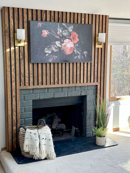 Up the cozy factor of your fireplace with brass wall sconces, a super thin tv that displays beautiful art, and cute home decor accents like plants, baskets, and blankets. 

Sconce | lighting | wall lighting | modern light | brass | fireplace | faux plants | tv | flatscreen 

#LTKunder50 #LTKhome