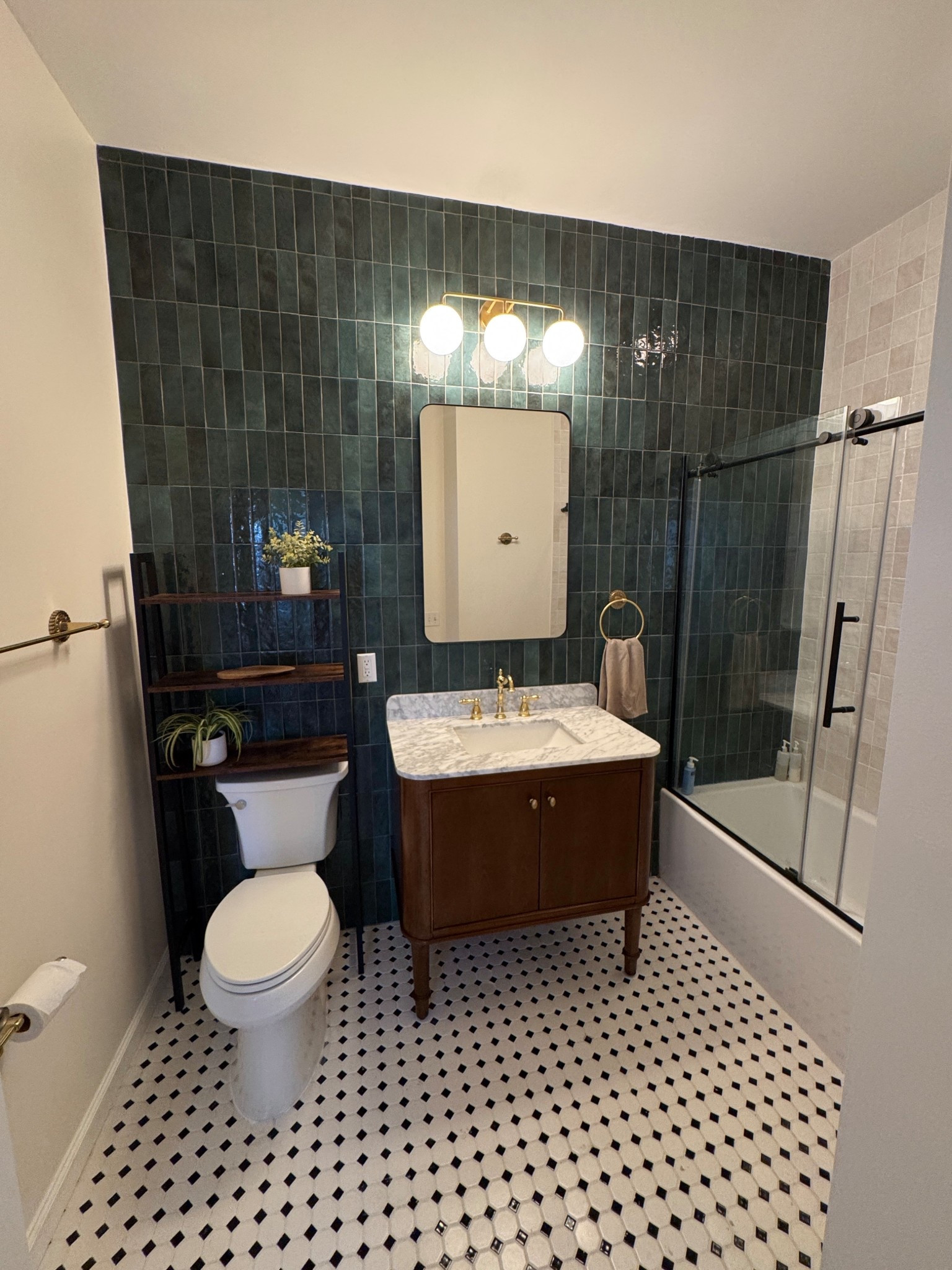 I am truly obsessed with how the designs turned out for our guest bathroom! The rectangular green tile is the main feature of the room and we did the entire back wall in it. I found this brown vanity at the Home Depot with the marble countertop and paired it with a brass faucet that’s very vintage inspired! I also got the Claudette brass towel bar, toilet paper holder, and towel ring they are so cute! I love the round three light above the vanity too and the clear bathtub door with the black hardware. It all came out so great! 

#LTKFindsUnder100 #LTKHome