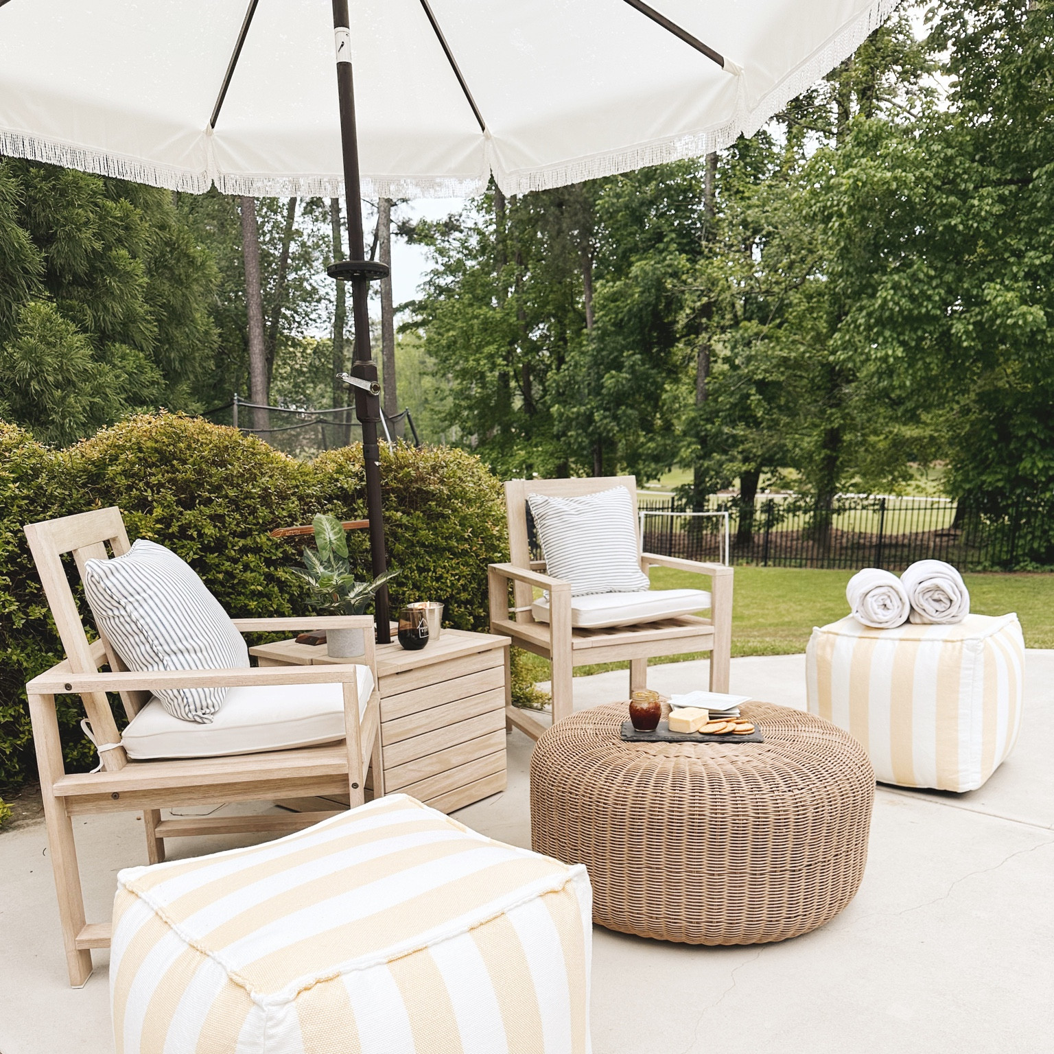 Outdoor Patio furniture from Target and Pottery Barn // seating area on Emily’s pool deck with poufs, chairs, fringe umbrella, wicker outdoor coffee table, pillows and umbrella storage holder ☀️ #target #potterybarn

#LTKSeasonal #LTKhome #LTKswim