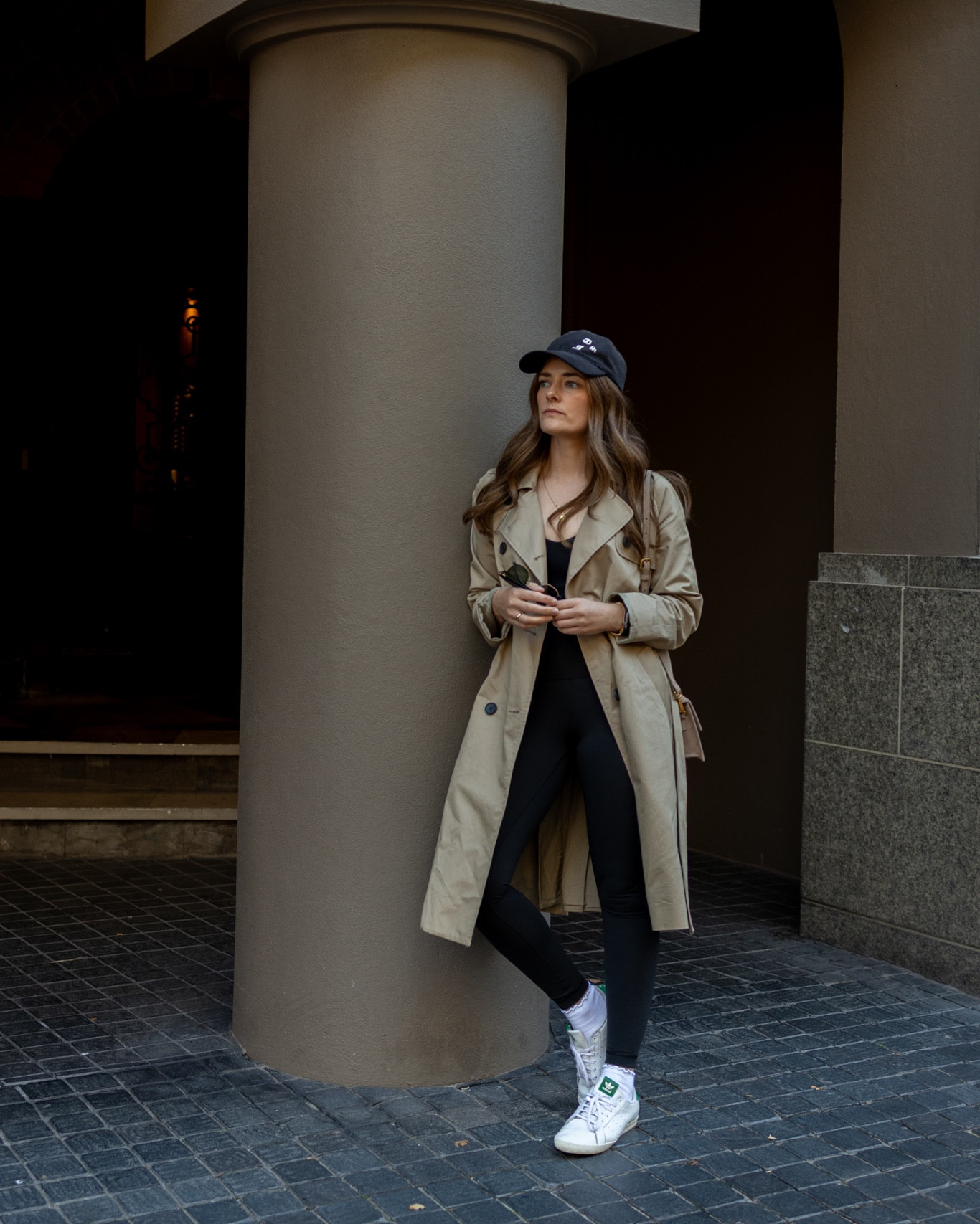 Pre Pilates outfit idea with black leggings and tank top and trench coat layer. A chic baseball cap finishes the look. 

#LTKstyletip #LTKaustralia #LTKFitness
