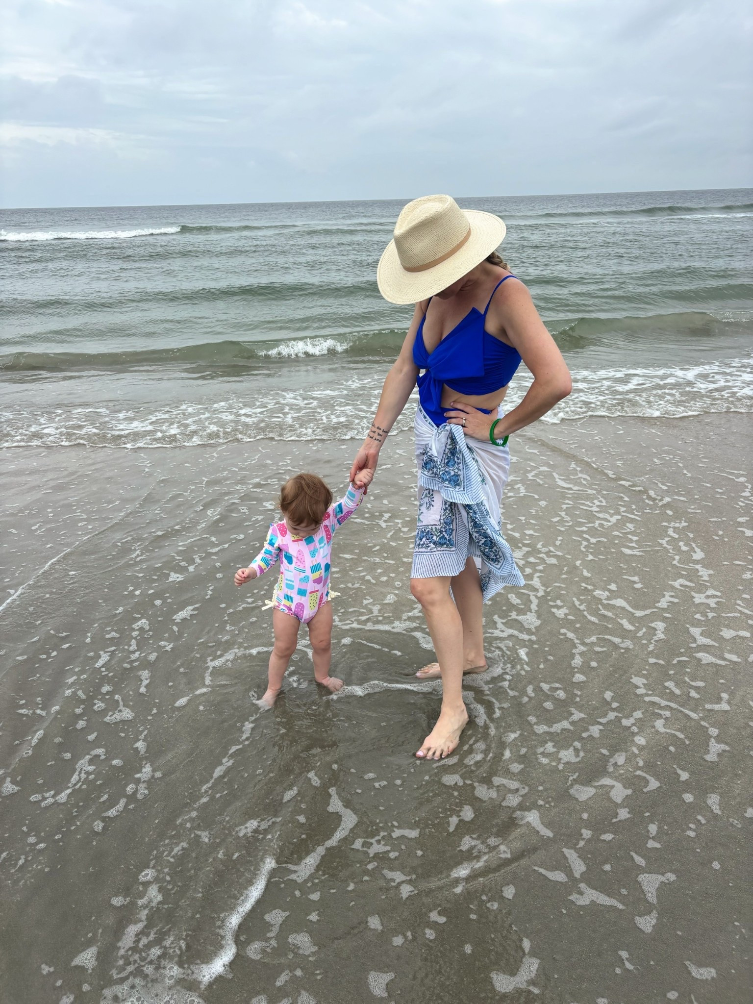 ☀️🍦 Beach day ready in the sweetest mommy & me swim looks! My little one is rocking the RuffleButts UPF 50+ long sleeve rash guard in the playful “Ice Cream Social” print 🍭—perfect for all-day sun protection and splashing in the waves 🌊. I paired my cobalt blue bow bikini with a hand block printed cotton sarong for a breezy coastal vibe 💙, and topped it off with the chic Janessa Leoné Sherman packable straw fedora 👒 for the ultimate sun-safe style.

🛍 Baby suit: Amazon | $24.98 (12–18M)
🛍 My bikini: Amazon | Size S
🛍 Sarong: Amazon | Indigo Blue Floral
🛍 Hat: Janessa Leoné | Sherman Fedora

#LTKKids #LTKBaby #LTKSwim