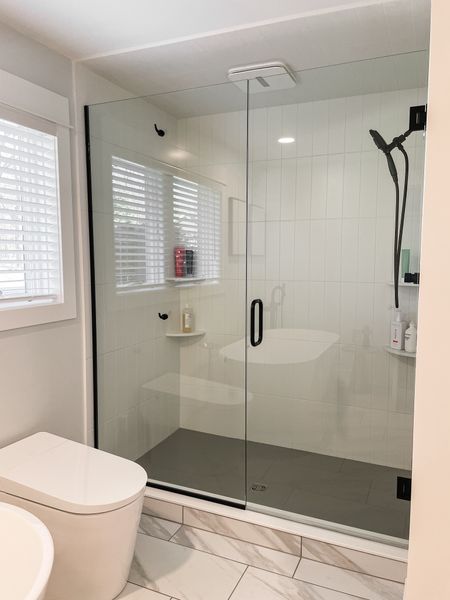 These client bathroom shower is stunning.  We saved money on the wall and shower floor tile.  But stacking it makes it feel luxurious.  

Modern bathroom shower.  Black shower fixture.  White toilet bidet.  Gray mosaic hexagon tile.  Shower door.  

#LTKstyletip #LTKhome #LTKfamily