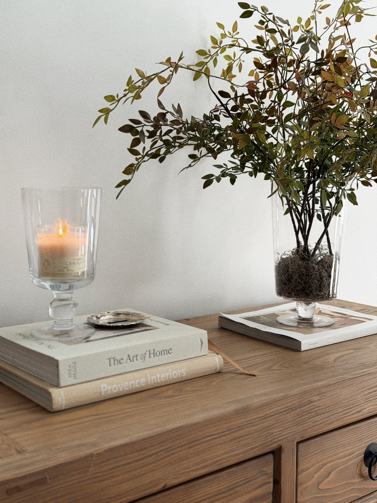 console table styling - hurricane holder, spring stems, book styling 

#LTKdayinmylife #LTKHome #LTKselfcare