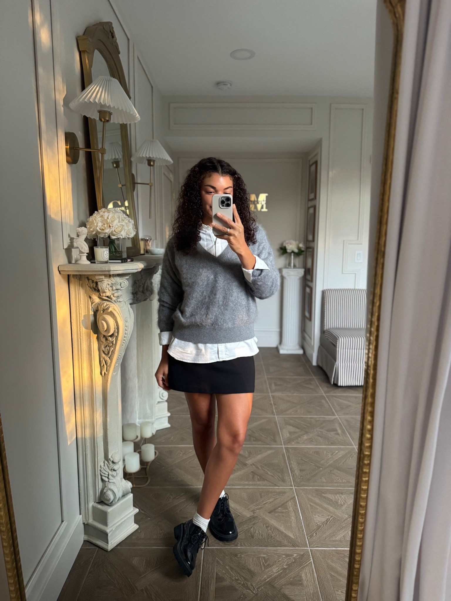 Fall outfit with preppy vibes: oversized button up shirt, v neck sweater, black mini skirt, trouser socks, and derby shoes 

#LTKStyleTip #LTKSeasonal