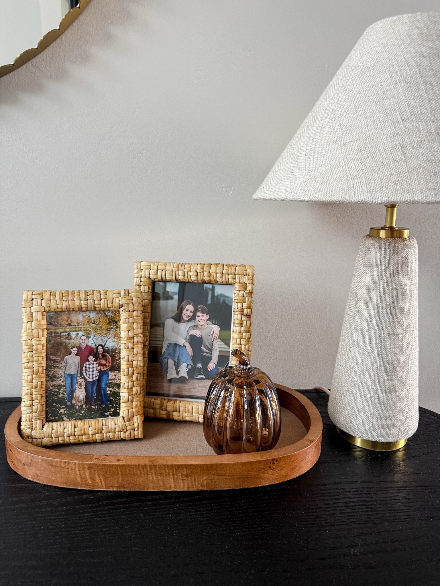 A few simple fall touches for the entryway 🍂 Love the woven frames, warm wood + little glass pumpkin. #FallDecor #EntrywayDecor