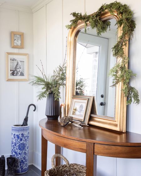 This year’s very simple Christmas mudroom. Traditional demi lune console table, gold arch mirror, and chinoiserie umbrella holder with fresh greenery.

#LTKSeasonal #LTKhome #LTKHoliday