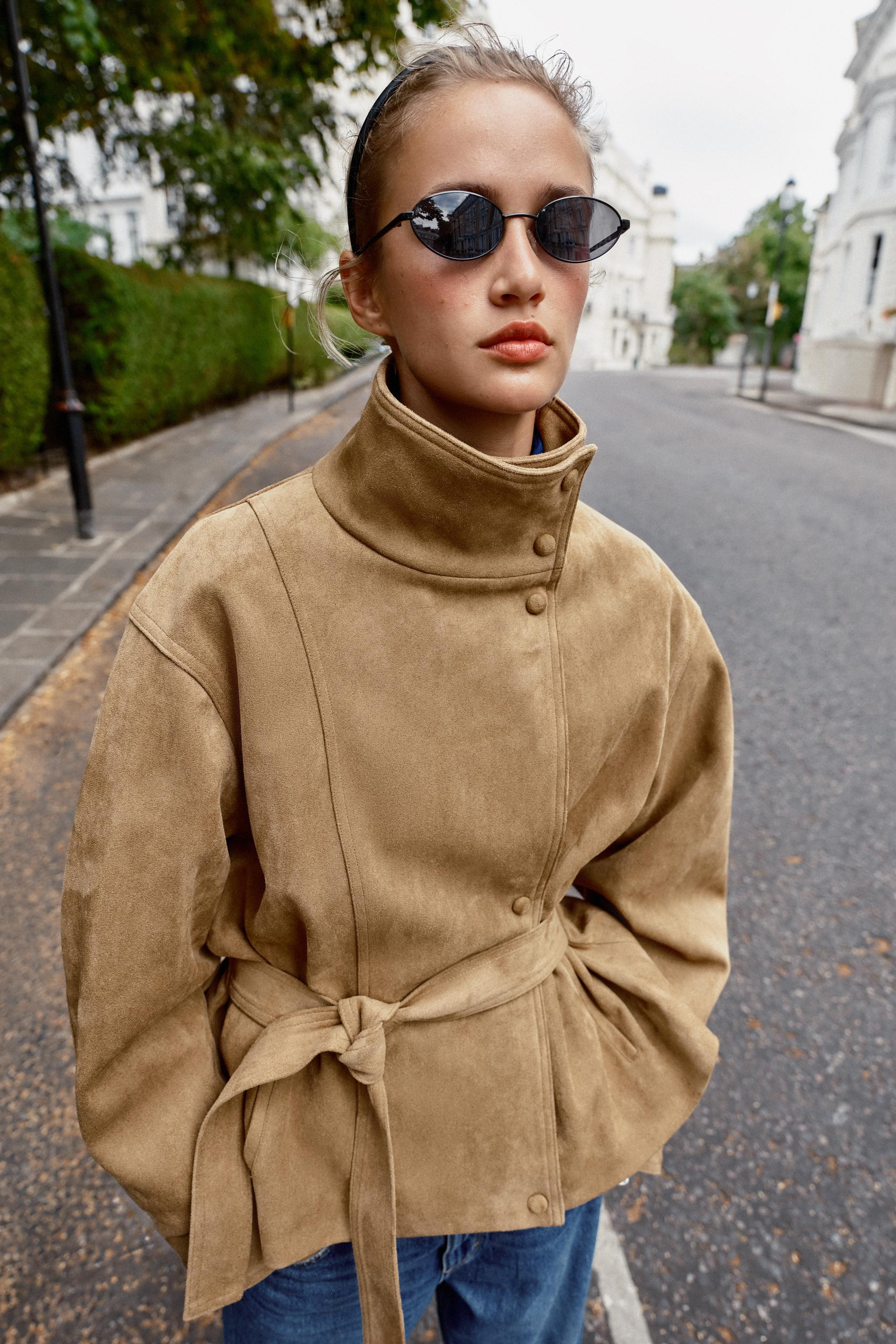 Stand-up collar jacket with long sleeves. Features front pockets. Matching fabric belt detail and... | Zara US