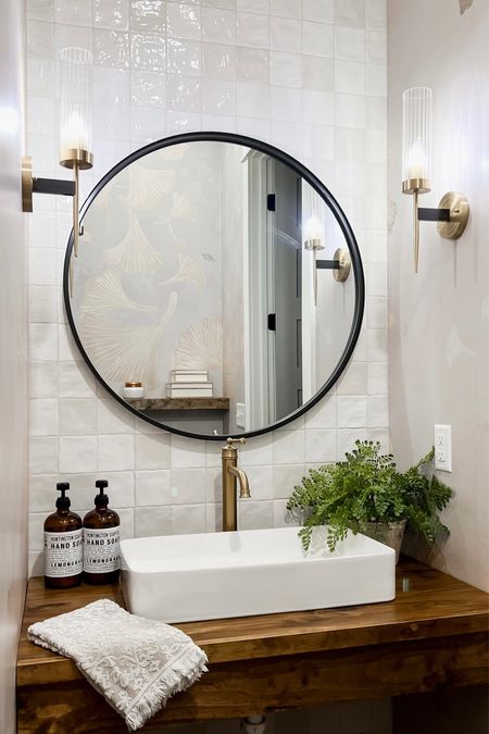 Bathroom design gold wall sconces light fixture  round oversized black mirror vessel sink faucet amber glass hand soap faux artificial silk fern modern farmhouse style home accessories and decor powder room 

#LTKhome #LTKstyletip #LTKFind