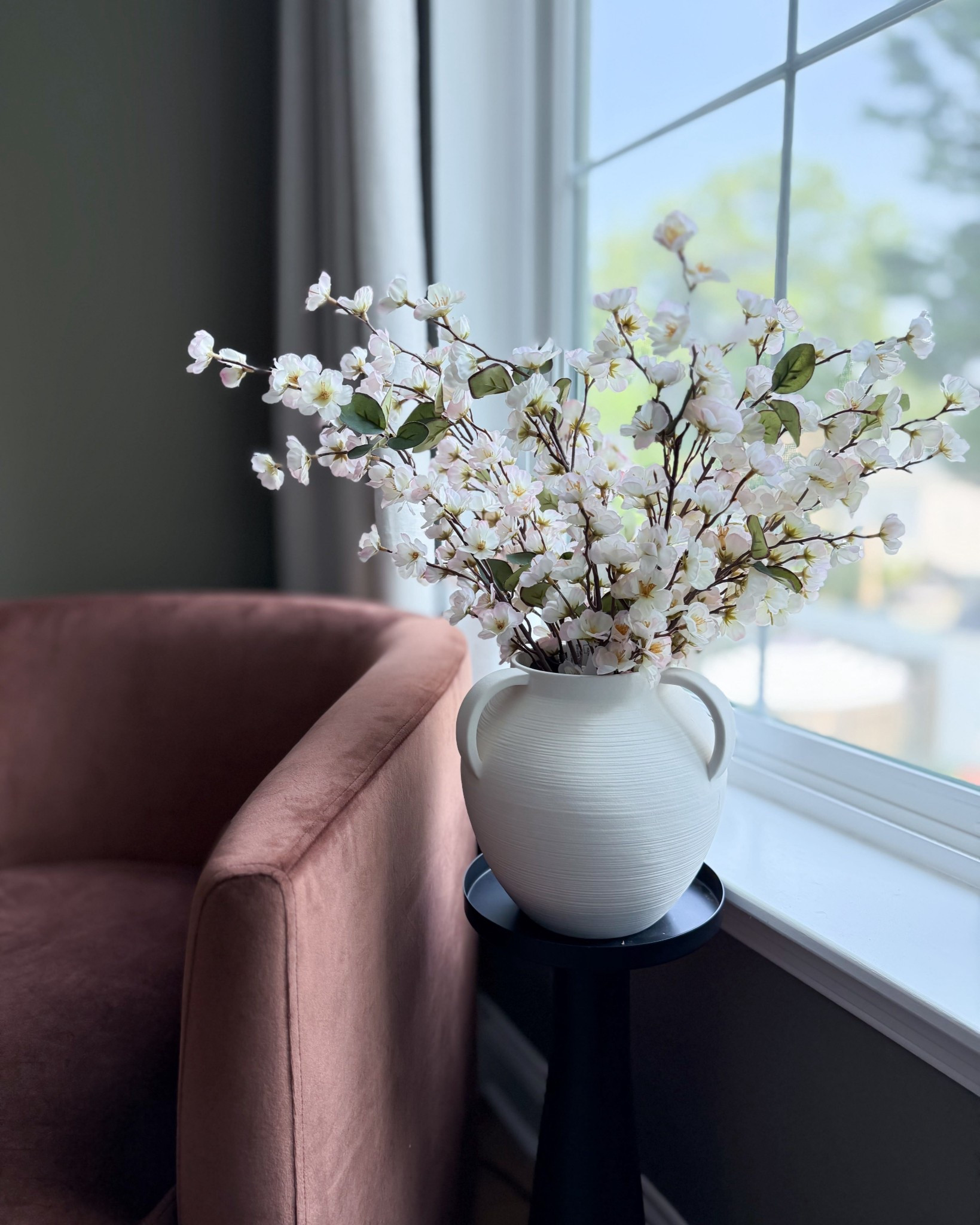 This velvet swivel chair from Target is the perfect pop of blush in a neutral living room. I paired it with faux stems in a matte white vase to add height and softness near the window. A cozy corner moment that works year-round.

#LTKStyleTip #LTKHome #LTKOver40