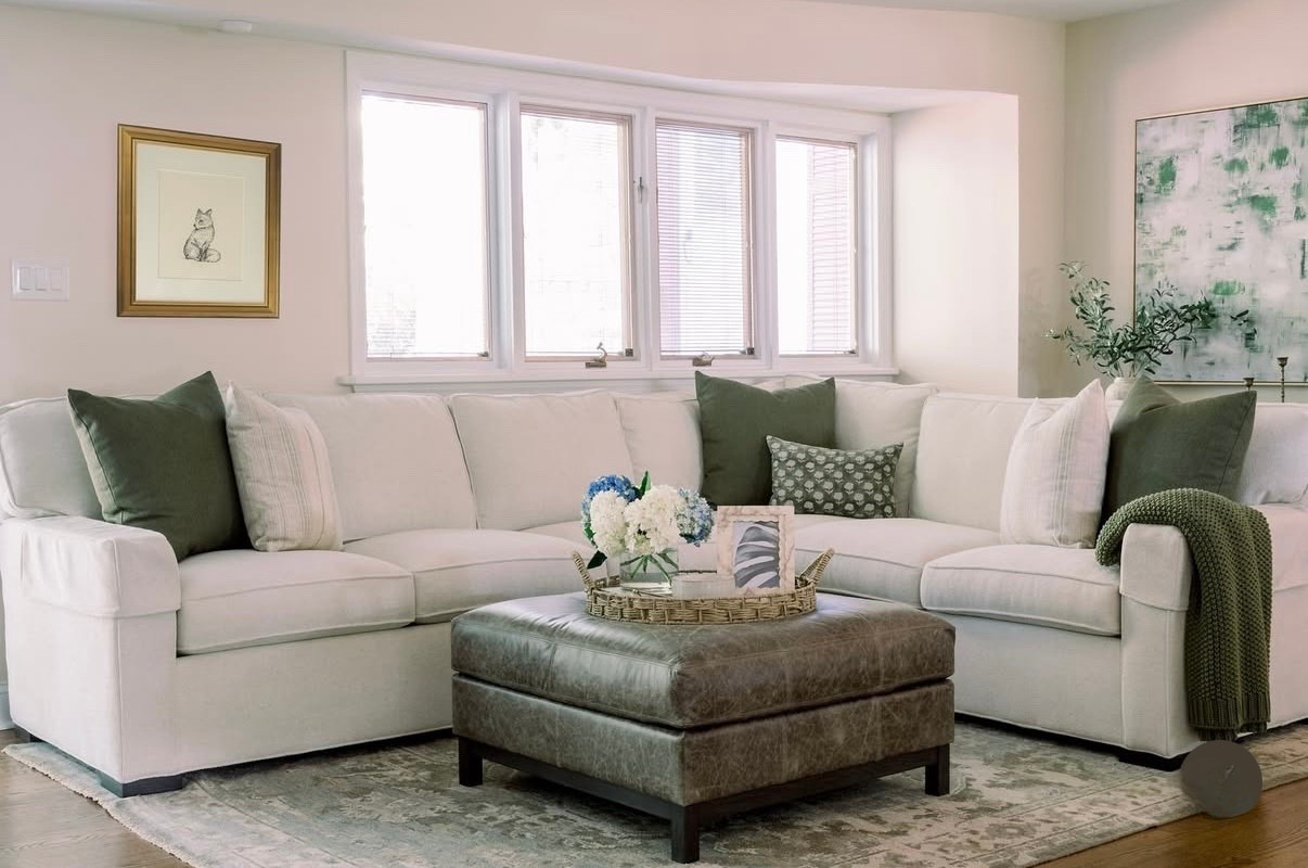 ✨ Neutral tones, layered textures, and a pop of greenery = effortless living room bliss 🌿🤍 This ivory sectional is the perfect backdrop for seasonal styling, paired with deep green pillows, a knit throw, and a rustic leather ottoman for contrast. The woven tray with hydrangeas ties it all together, giving a fresh yet timeless look.

🛋️ Shop the look below! 

#LTKU #LTKStyleTip #LTKHome