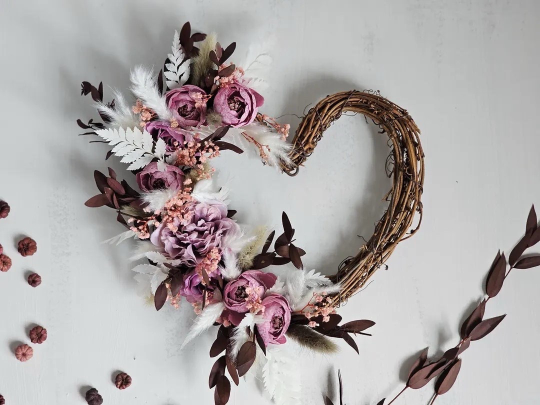 Add a soft romantic touch to your space with this beautiful heart-shaped wreath by BlossomBeGifts. Crafted on a natural grapevine base, it features real-touch peonies in lilac and dusky mauve tones, paired with burgundy preserved eucalyptus, pampas grass, delicate gypsophila, dried berries, and airy feather accents. The layered textures and muted colors create an elegant statement piece that’s perfect for doors, walls, weddings, or gifting for Mother’s Day, birthdays, or housewarmings. A timeless keepsake that brings charm and warmth to any home. 💕🌿

#LTKhome #LTKdecor #WreathDecor #HeartWreath #GiftIdeas #MothersDayGift #RomanticDecor #FloralStyling #BlossomBeGifts

#LTKSeasonal #LTKFindsUnder50 #LTKHome