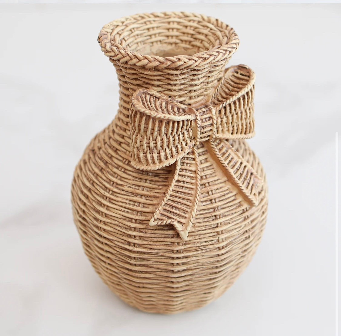 Add a sweet, textural touch to your styling with this Resin Woven Vase featuring a charming bow detail. Designed to mimic the look of natural wicker, it brings cozy cottage charm to shelves, trays, or bedside tables without the fragility of true woven materials

#LTKSeasonal #LTKHome #LTKValentine