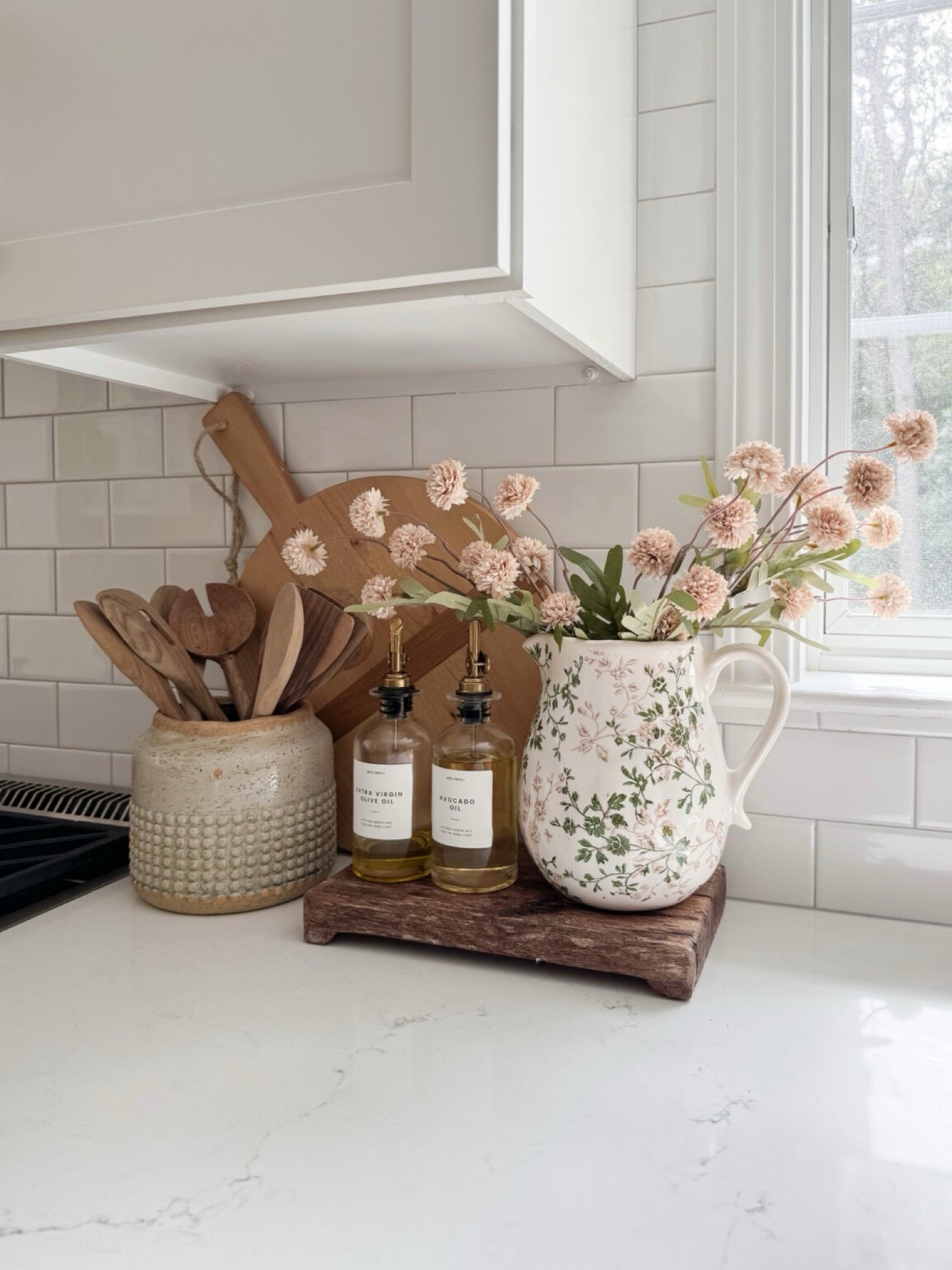 Kitchen countertop styling with oil and vinegar dispensers, floral pitcher vase, silk mums, and wood cutting boards for warm neutral kitchen decor.

neutral kitchen styling, oil and vinegar dispensers, floral pitcher vase, silk mums decor, kitchen counter styling, wood cutting boards decor, neutral kitchen accessories, coastal kitchen decor, sherricalnanhome 

#LTKHome