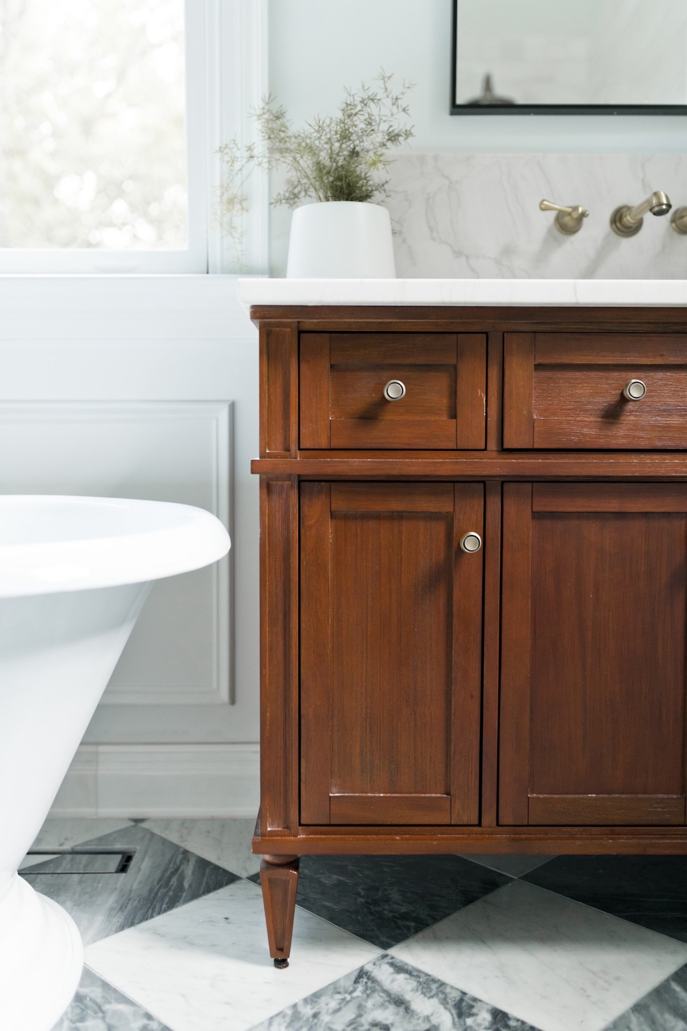 This bathroom renovation revolved around the vanities. The size, the color, the wood, the quality. The client wanted a vanity that felt like a piece of furniture, with legs and space underneath, and that warmed up the bathroom that was going to be cold feeling from the black/white checkered marble floors and white shower tile. This was the perfect piece! 

#checkeredfloors
#bathroomrenovation
#interiordesign
#luxurybathroom

#LTKHome