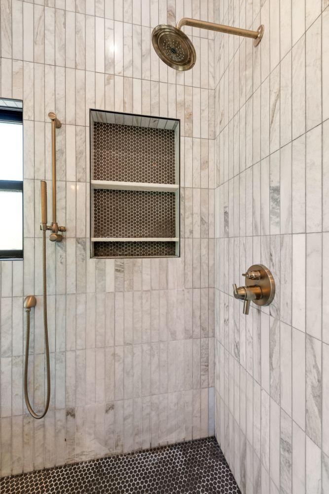 Sleek, warm, and timeless—this primary bathroom shower features vertically stacked warm marble tile, a bold black penny tile floor and niche, and elegant brass fixtures. 

#BathroomDesign #ShowerDesign #PrimaryBathroom #ModernBathroom #BathroomRemodel #InteriorDesign #HomeInspo #DreamBathroom #DesignDetails #RemodelGoals #VerticalTile #WarmMarble #MarbleTile #BlackPennyTile #ShowerNiche #BrassFixtures #LuxuryBathroom #TimelessDesign #HomeRenovation #SpaBathroom #ShowerBench #ShowerCurb #CustomTile #ModernClassic #FunctionalDesign #DesignBuild #RenovationInspiration 

 #LTKHome
