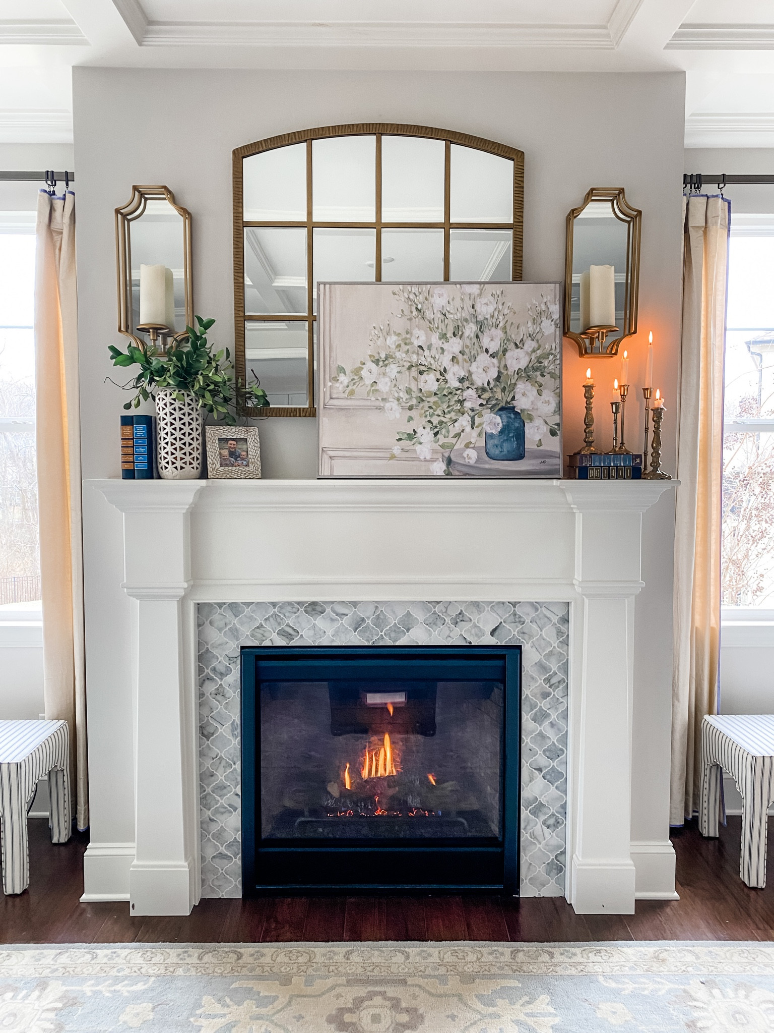 Living room mantle design and decor! Mirror sconces gold tapered candle holders framed artwork picture frame vintage books etc 

#LTKhome #LTKFind