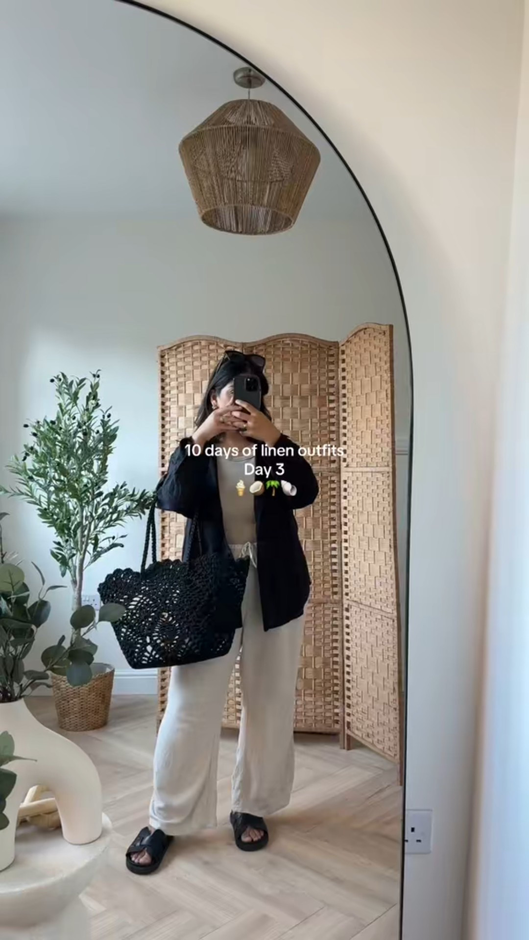 10 days of linen outfits - day 3

A black, loose-fitting linen shirt (10) worn open over a light beige or taupe tank top. The shirt gives off a crisp but breezy vibe.

Bottoms: Light beige or oatmeal-colored wide-leg linen trousers with a drawstring waist, adding to the comfort and effortless style (12)

A black crocheted or netted tote bag, ideal for a casual day out.
Black slide sandals.
	

#LTKpetite #LTKstyletip #LTKspring