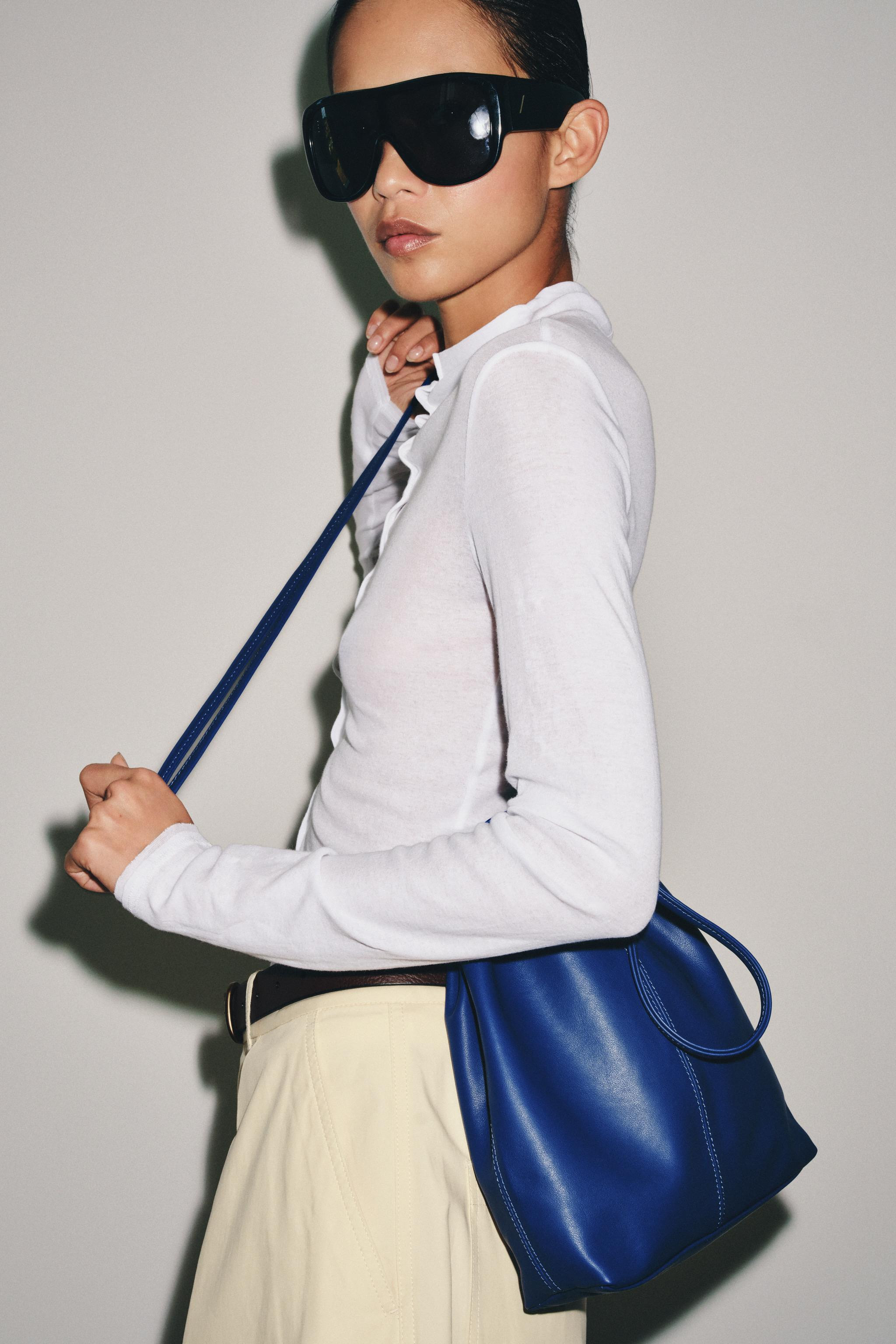 Leather crossbody bag. Features double handles, an interior pocket, topstitching detail on the bo... | Zara US