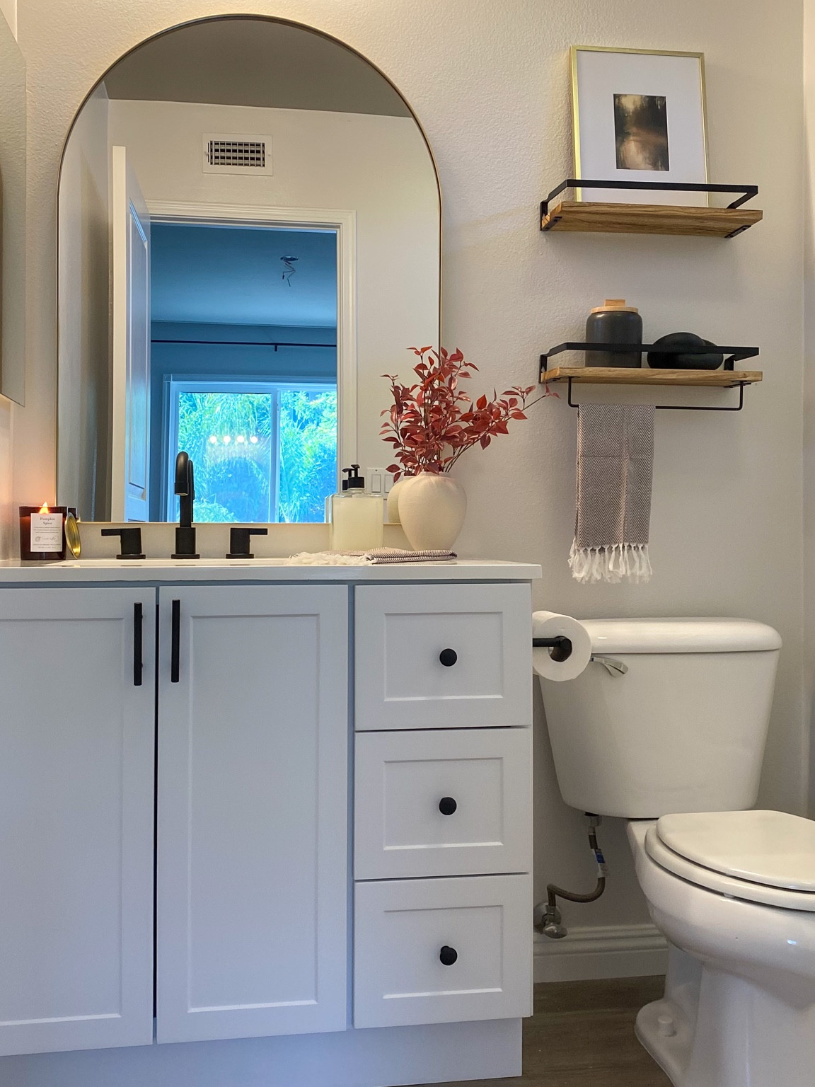 Bathroom decor. Bathroom vanity. Affordable vanity. Black faucet. Arch mirror. Vanity mirror. Arched mirror. Amazon decor. Floating shelves. Bathroom shelves. Wooden shelves. Hand towels. Bathroom accessories. Matted frame. Gold frame. Brass frame. Canister. Wooden knot. Bathroom towel. Fall plant. Pumpkin candle. Fall candle. Toilet paper holder. Bathroom trashcan. #amazonhome #amazon 

#LTKhome