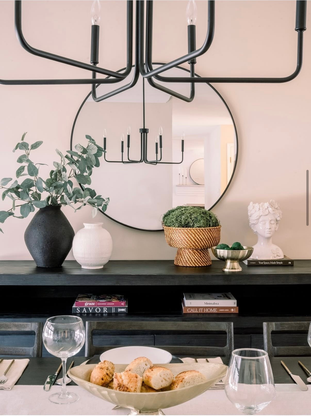 ✨ Dining details that make a statement ✨ A round mirror, stacked books, sculptural accents, and a touch of greenery keep this console styled and balanced while the chandelier reflection doubles the drama. Perfect mix of modern + timeless. 🖤🍃

#LTKHome #LTKU #LTKStyleTip